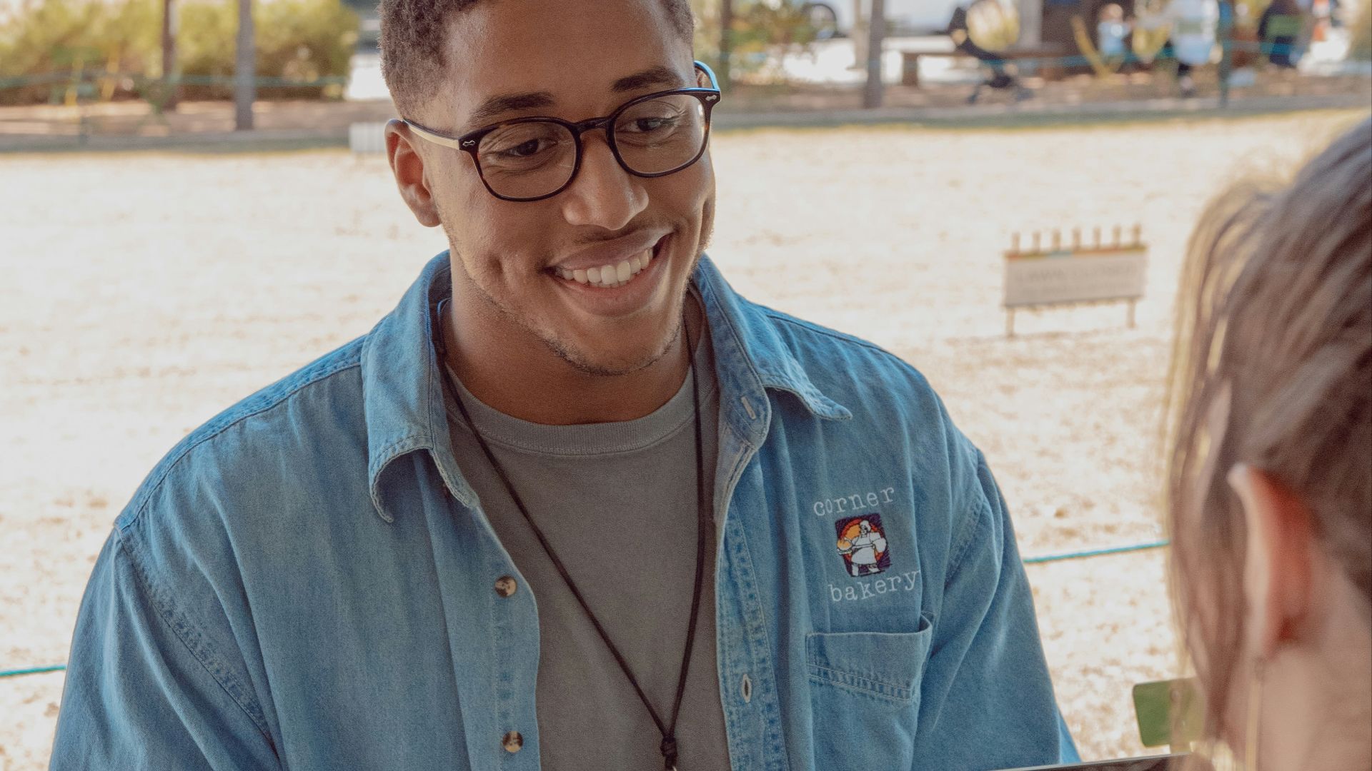 man wearing blue denim button-up shirt facing on human
