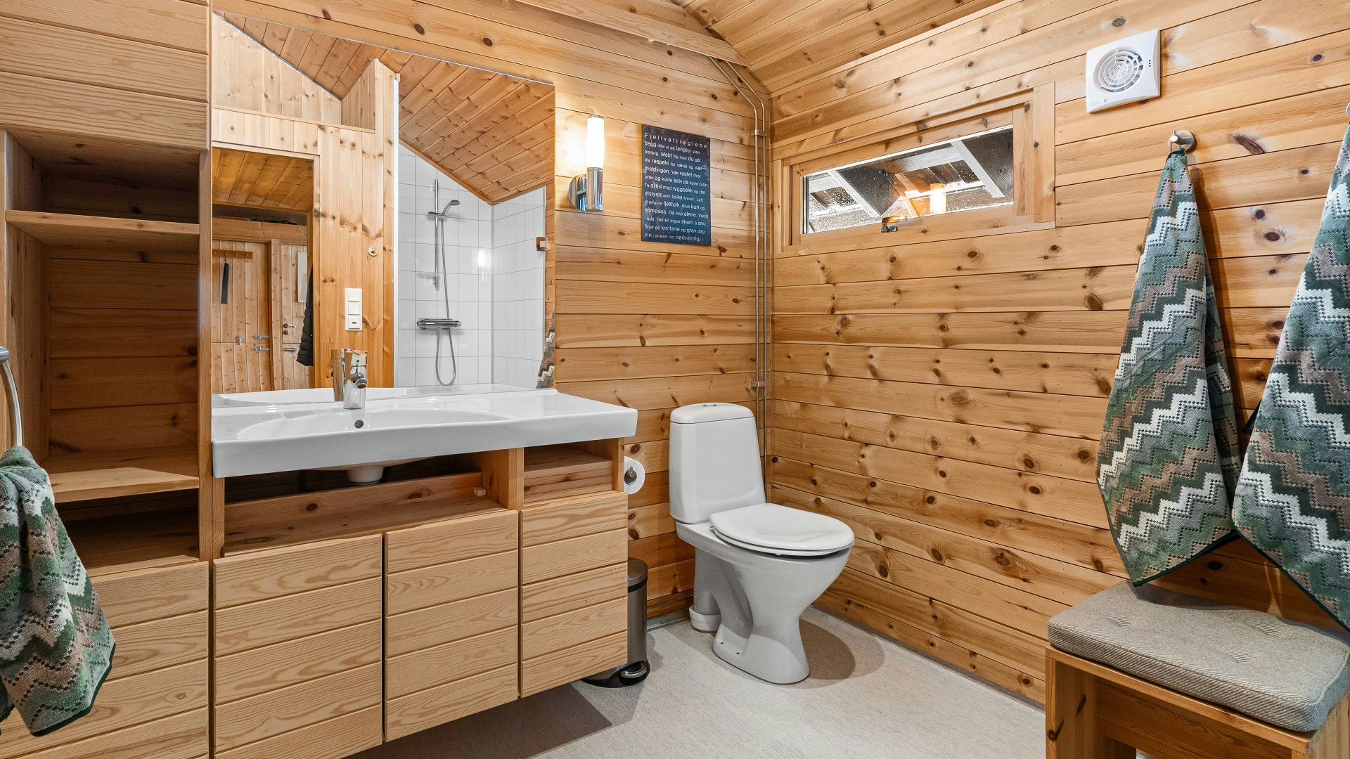 A bathroom with wooden walls and a toilet