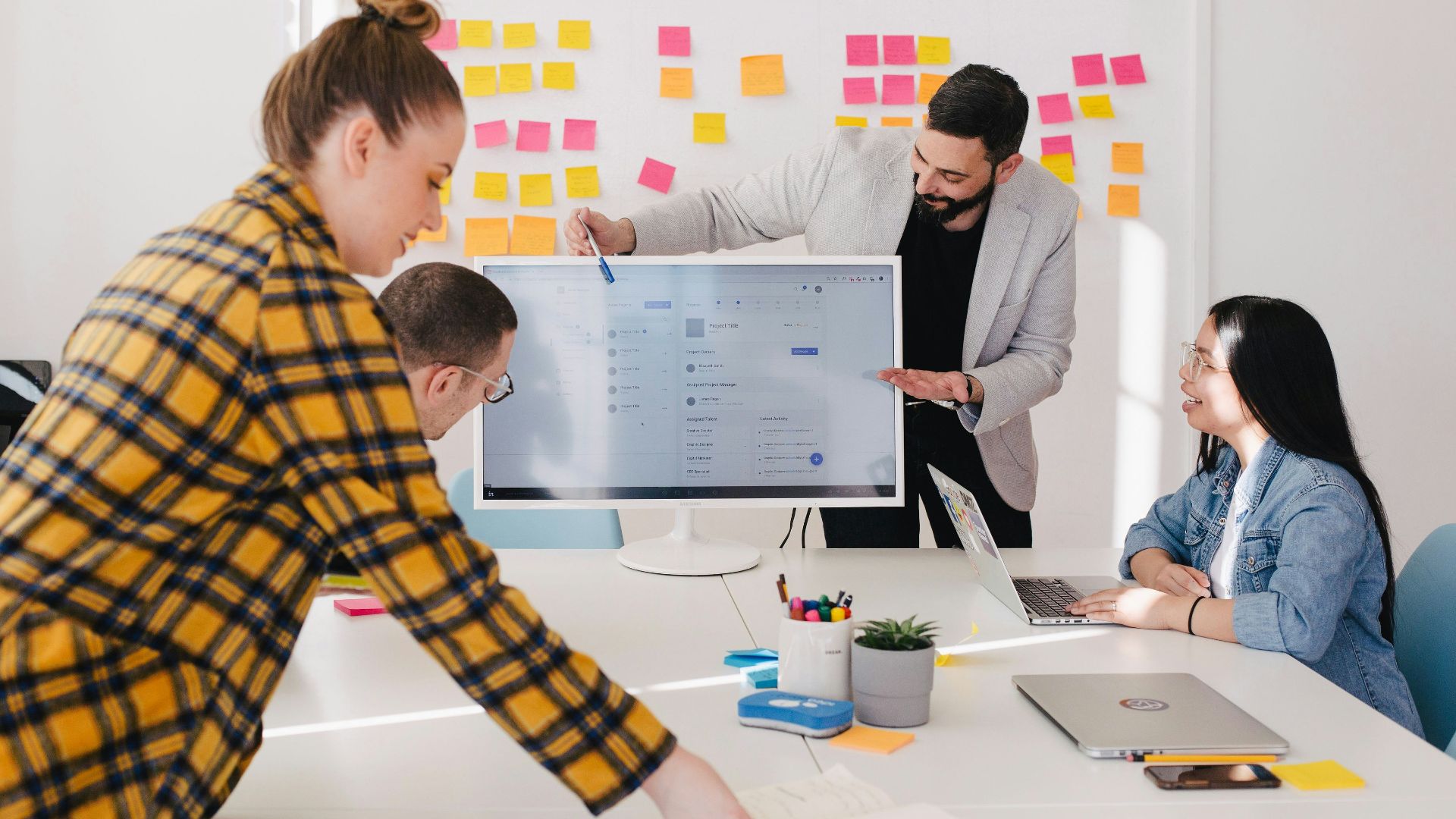 man standing behind flat screen computer monitor