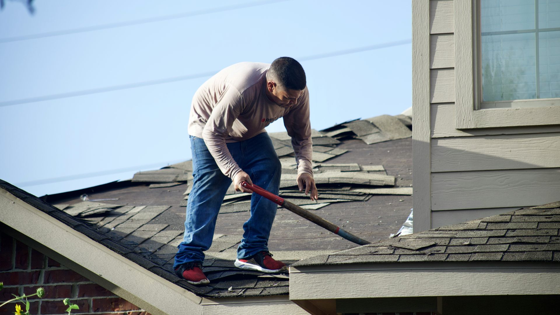 a man with a hammer on top of a roof