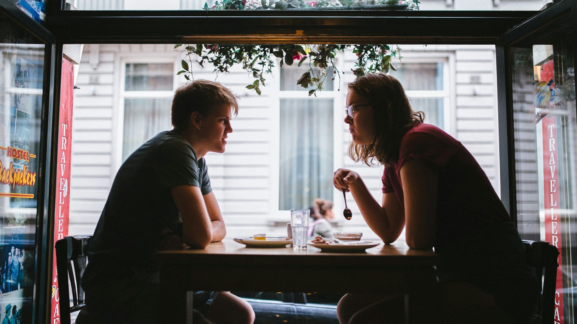 shallow focus photo of two men sitting in front of blakc wooden table