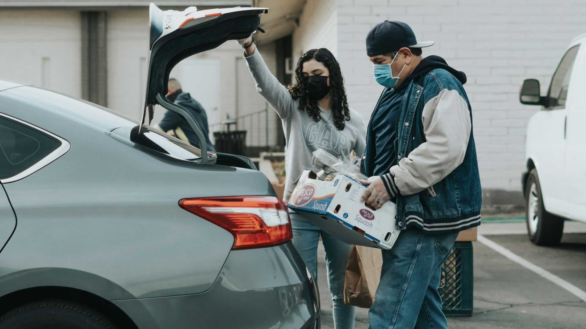 man in blue jacket standing beside woman in white jacket