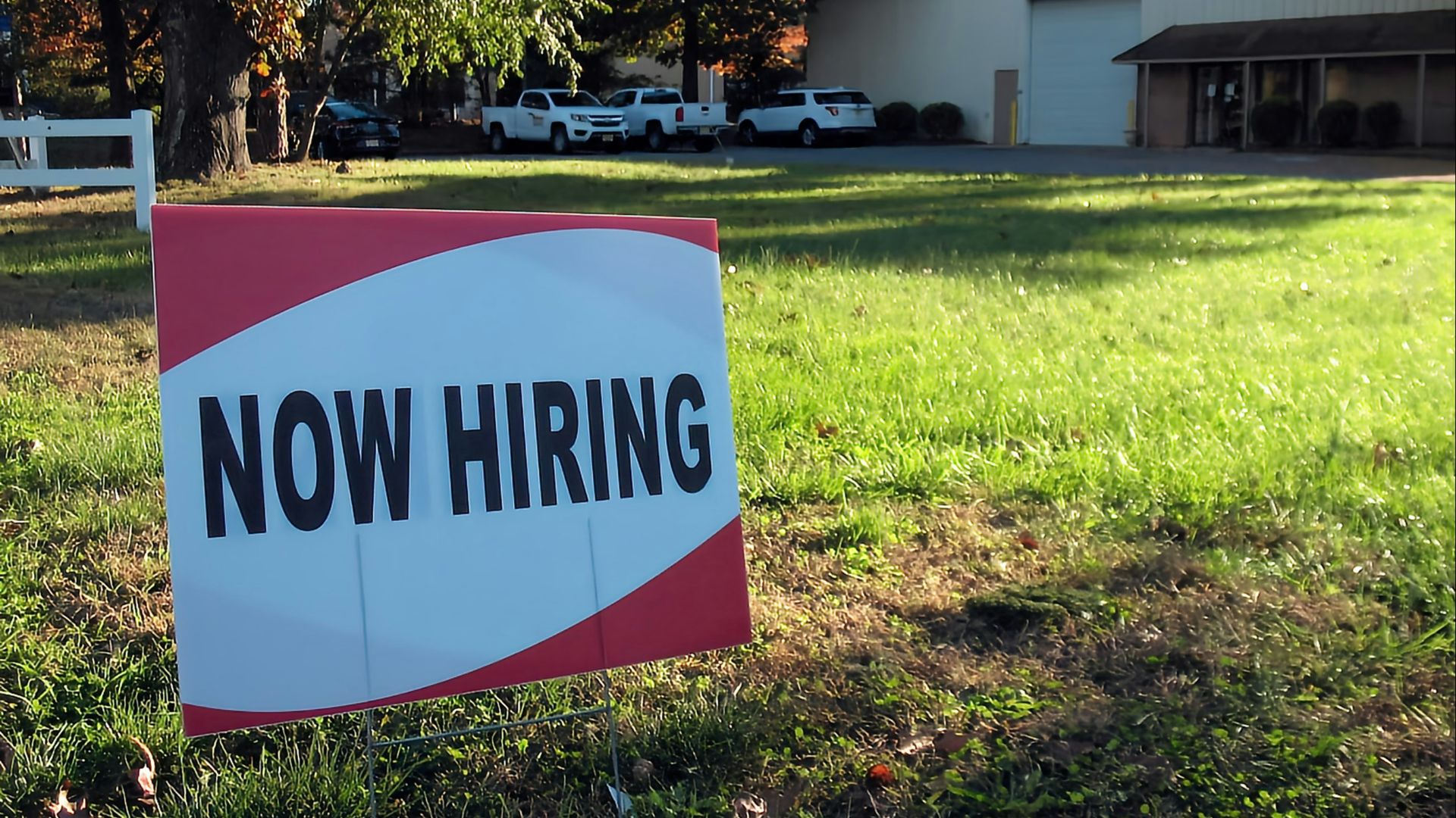 a now hiring sign in front of a building