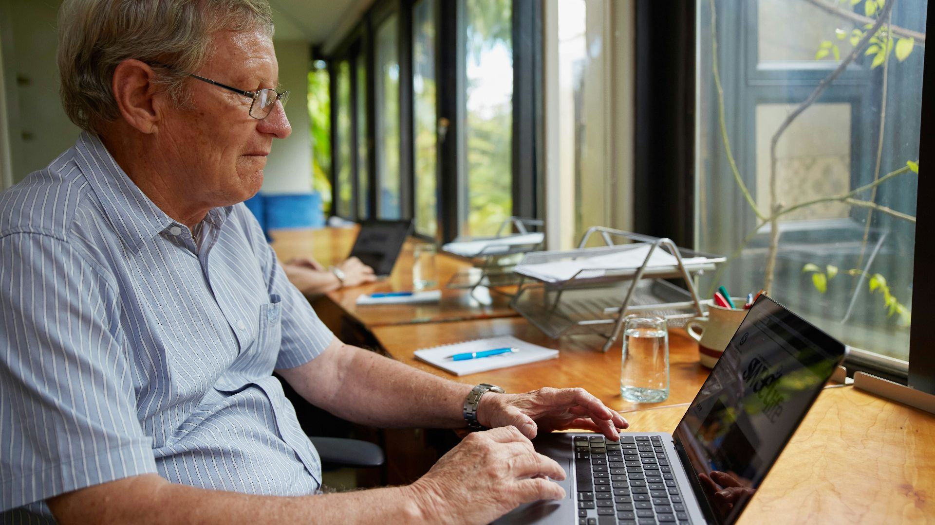a man sitting at a table using a laptop computer