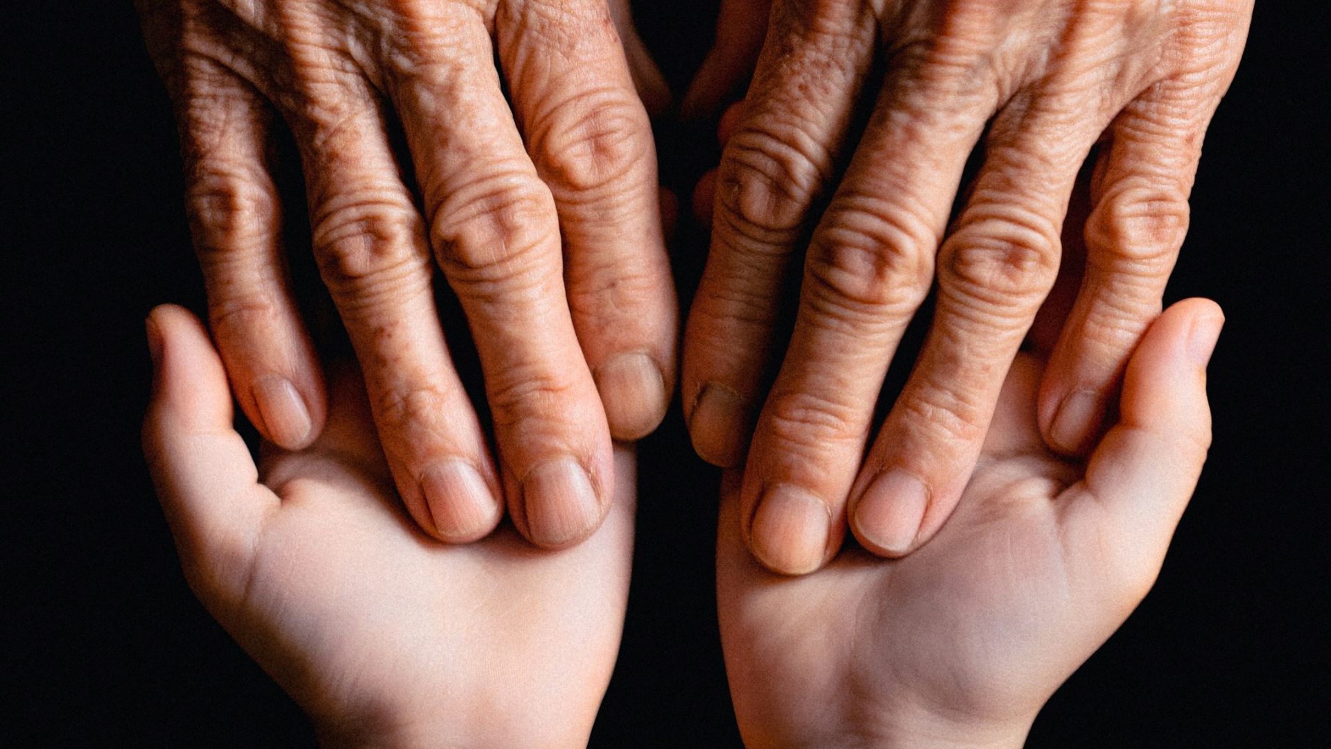 Old hands cradling the younger ones.