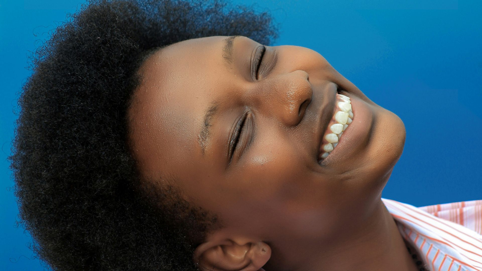 smiling girl in pink and white stripe shirt