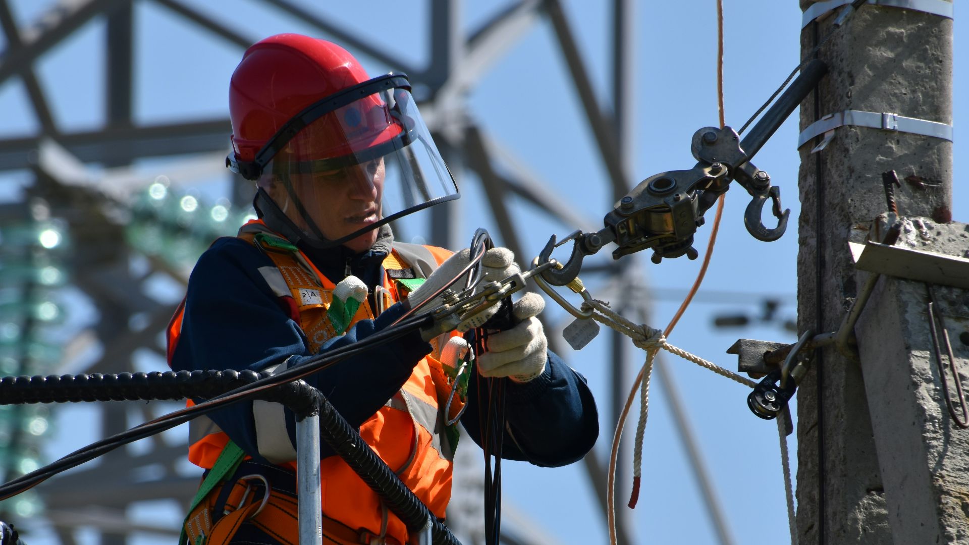 shallow focus photo of man fixing steel cable