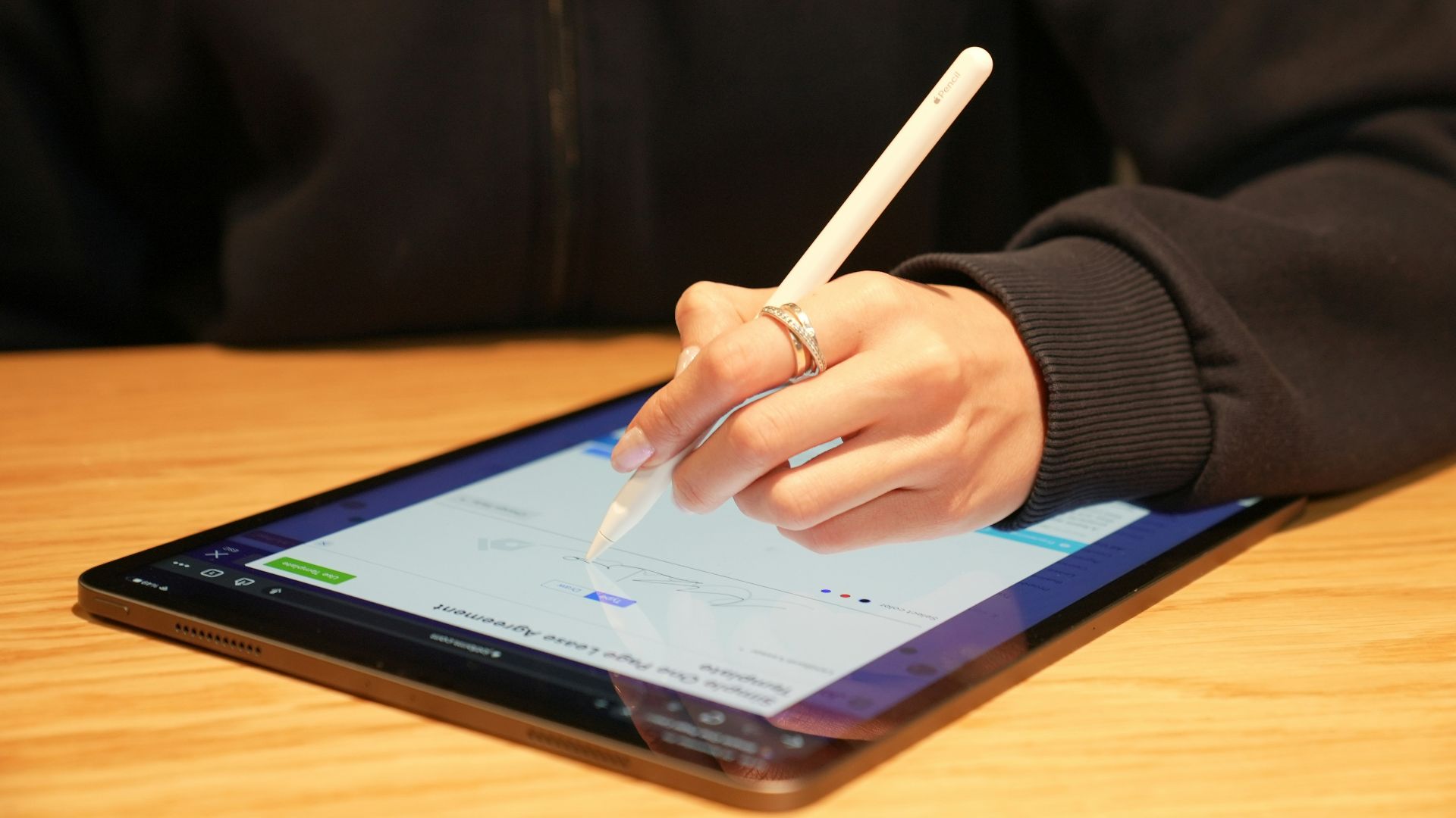 a person writing on a tablet with a pen