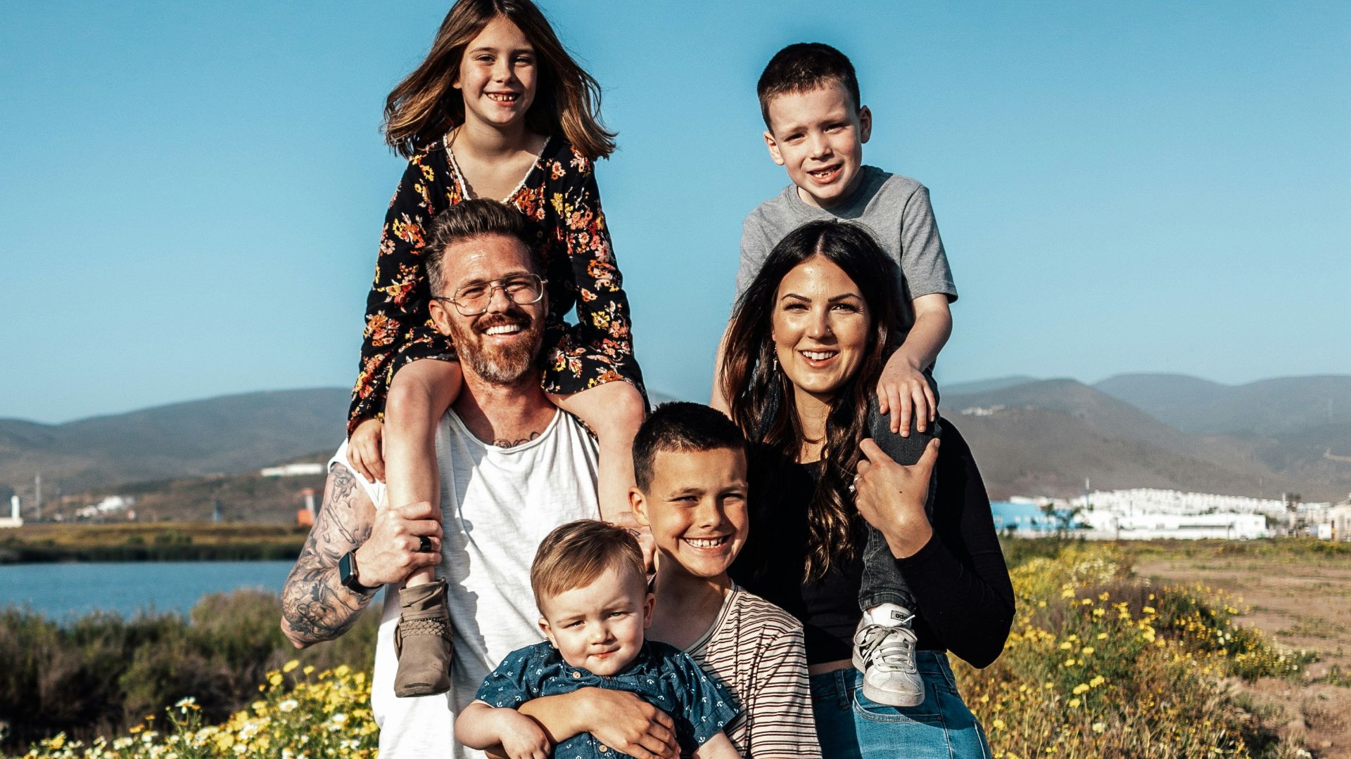 2 women and man standing on green grass field during daytime