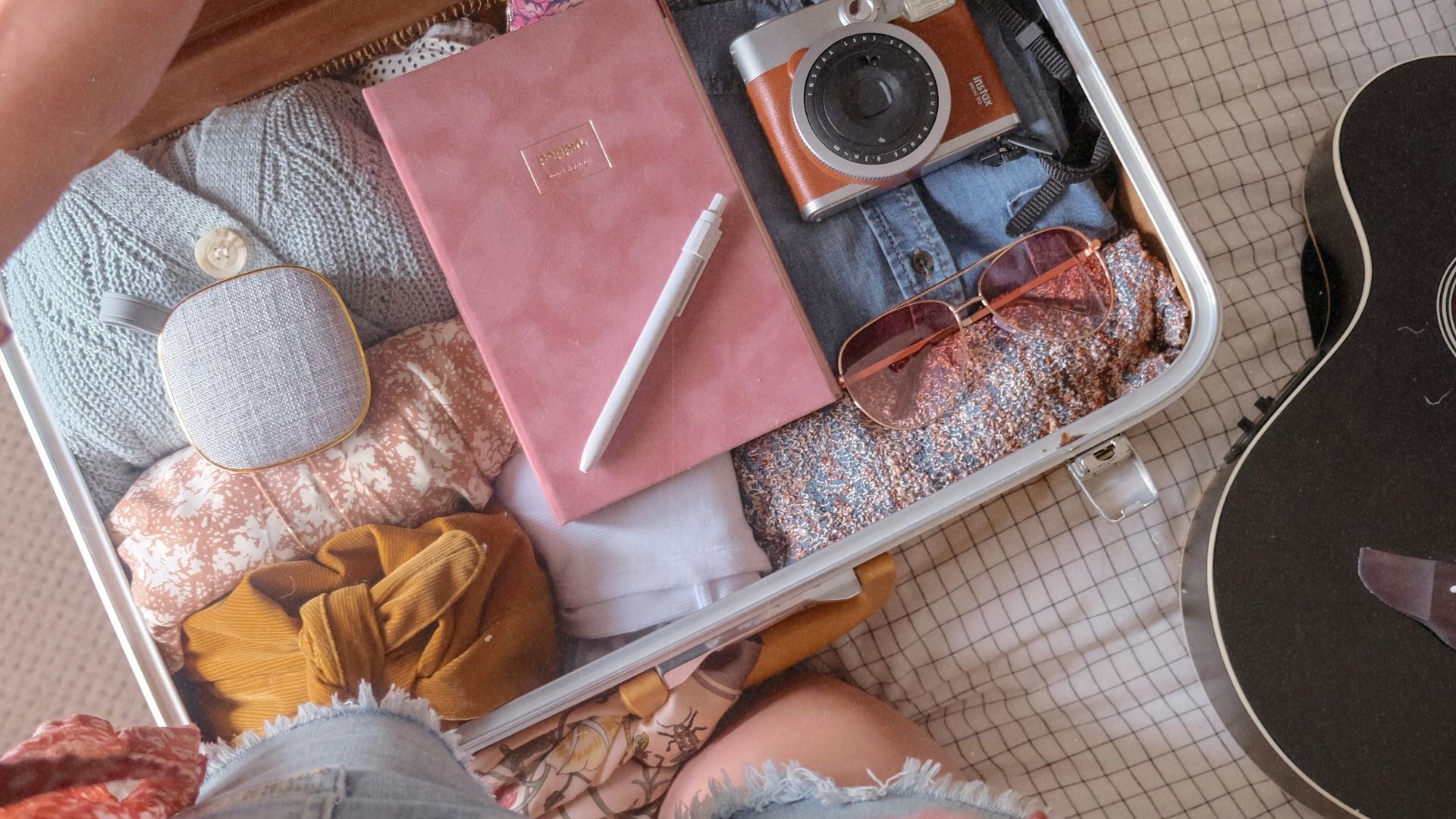 a person sitting on the floor next to a guitar