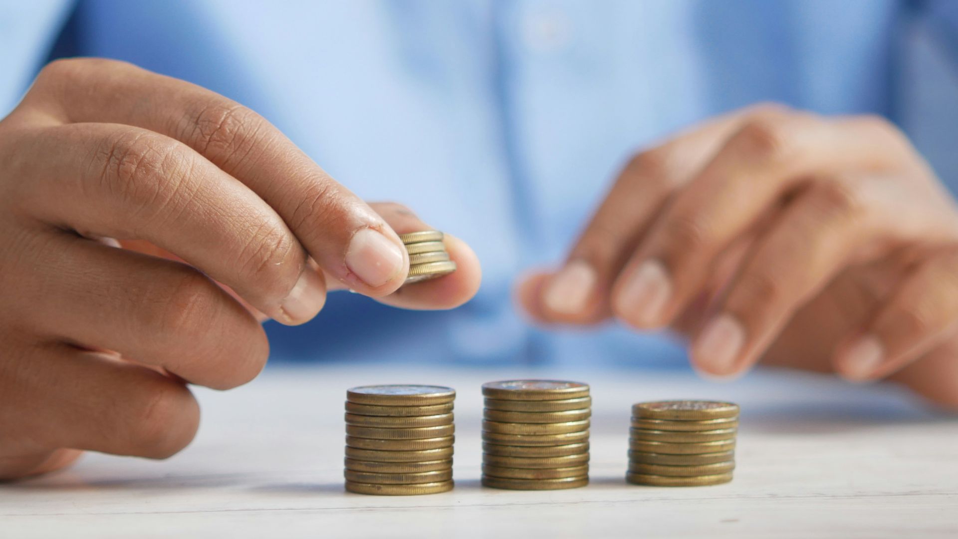 a person stacking coins on top of a table