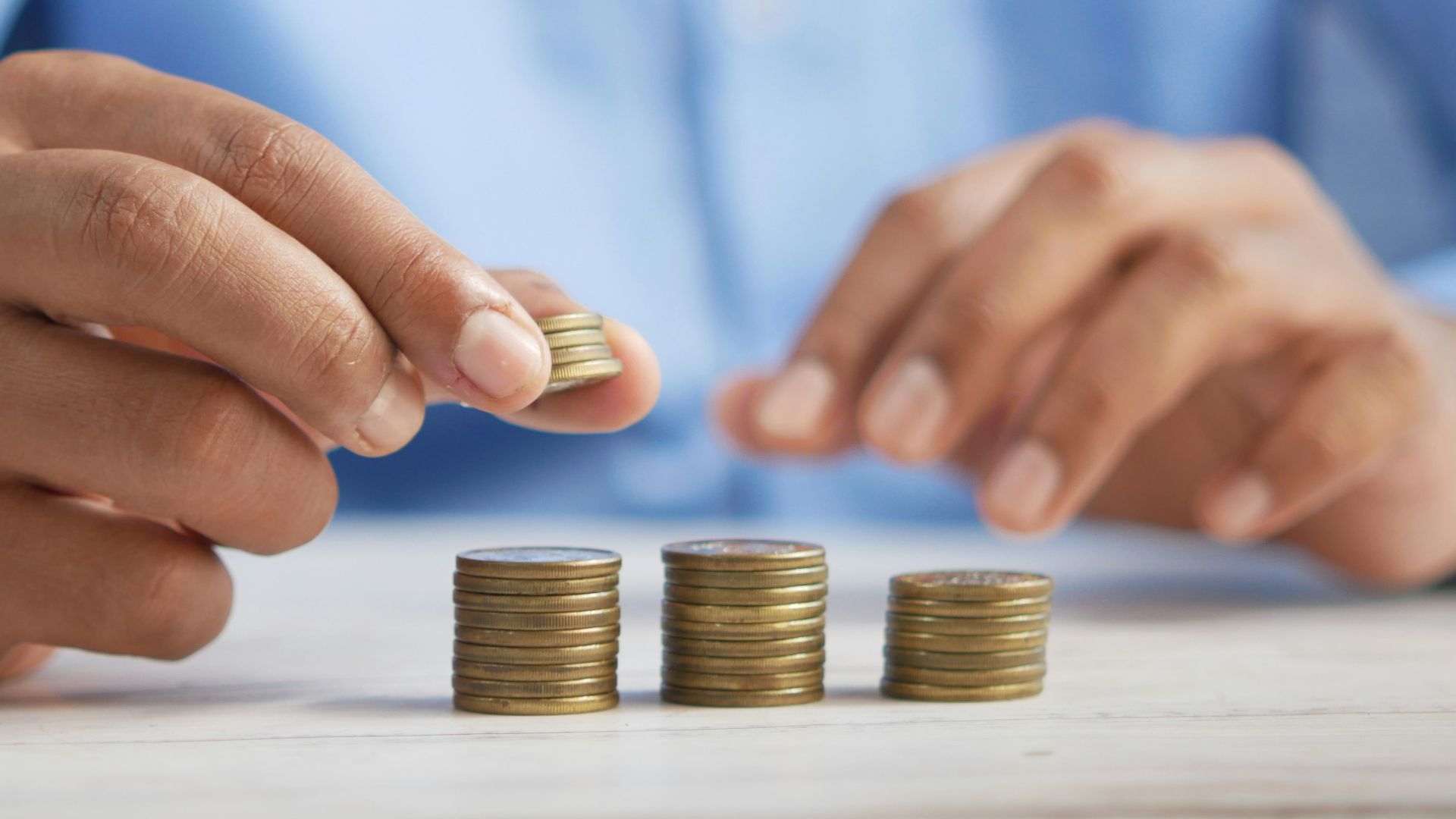 a person stacking coins on top of a table