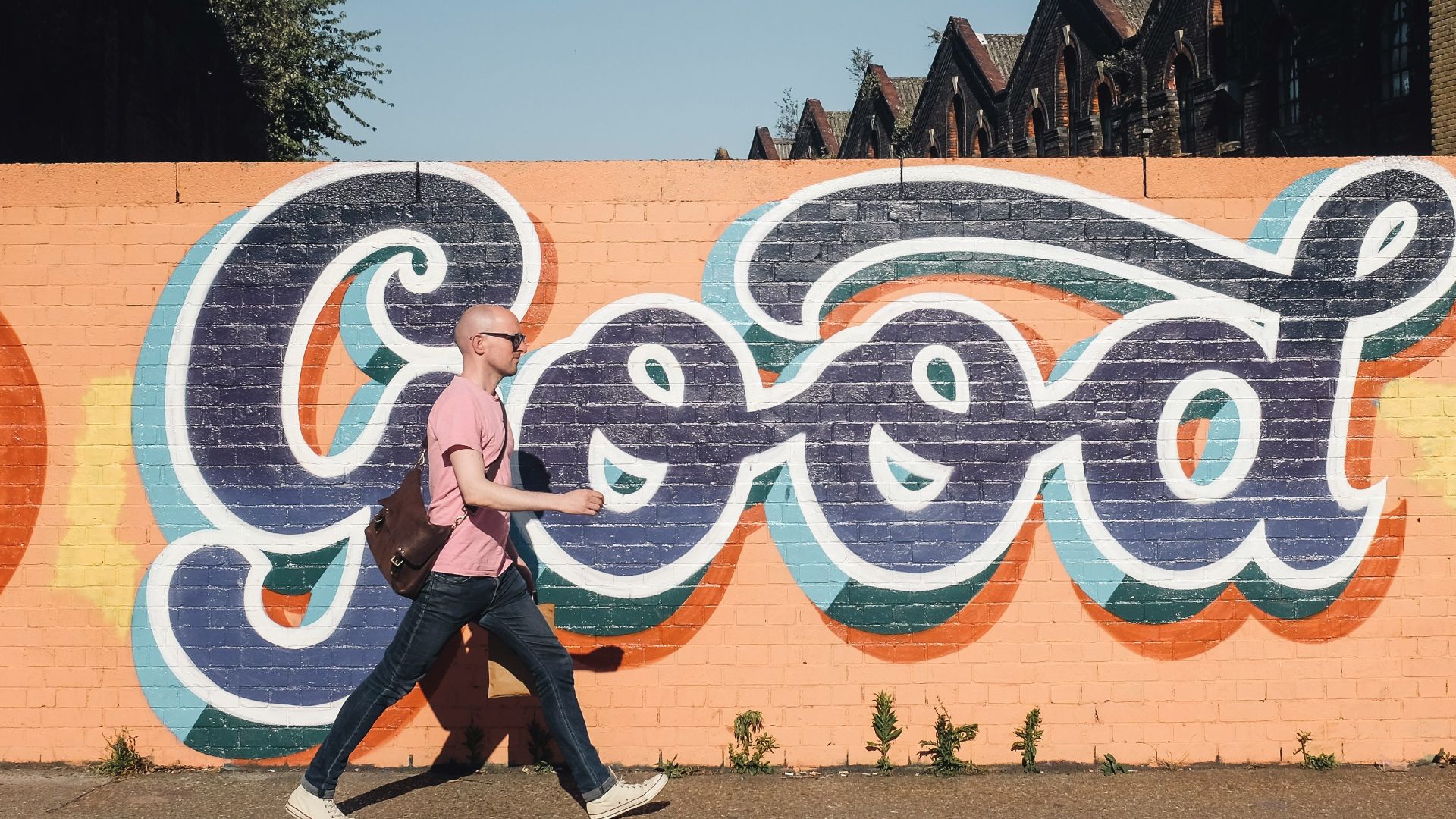 man walking beside graffiti wall