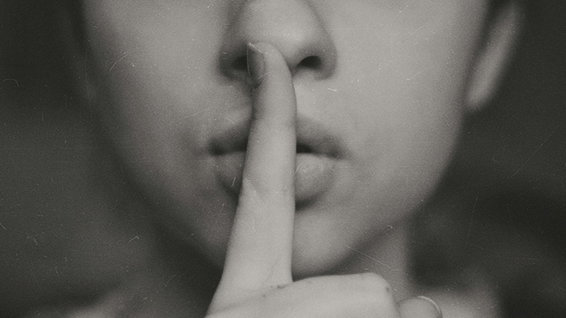 grayscale photo of woman doing silent hand sign