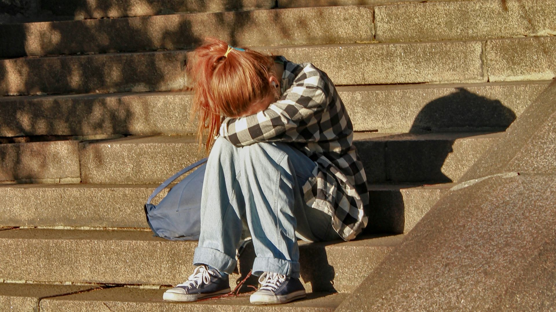 woman in black and white dress sitting on concrete stairs