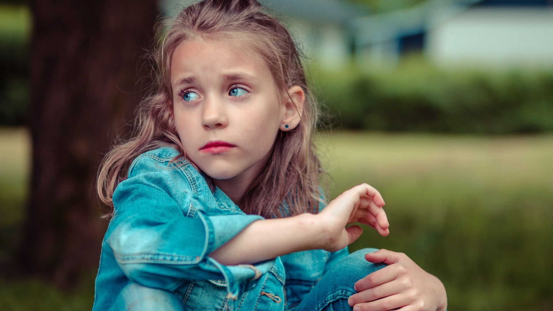 selective focus photography of girl sitting near tree