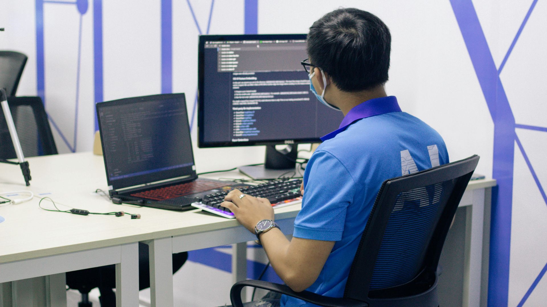 boy in blue t-shirt sitting on black office rolling chair in front of computer