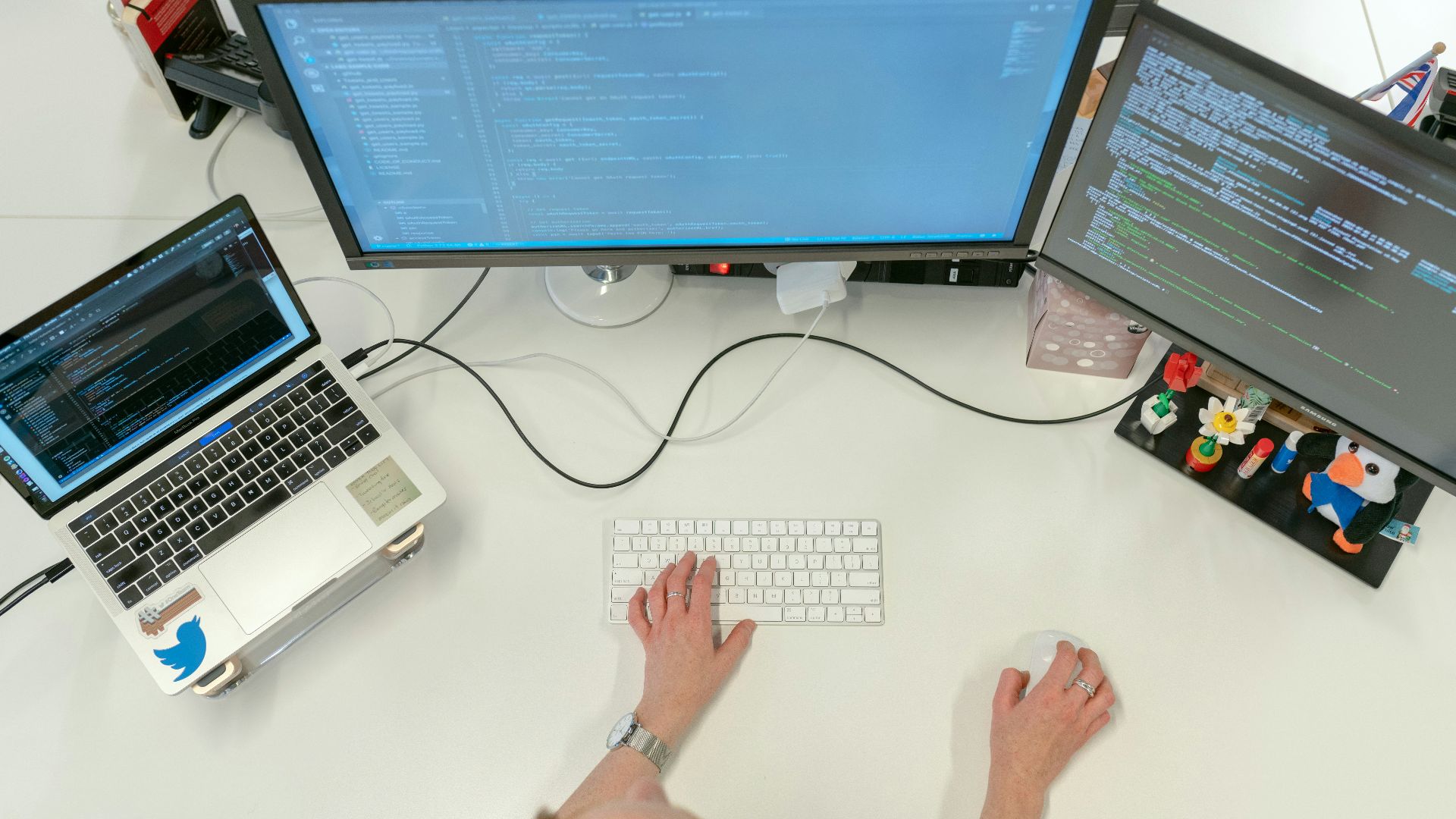 person using macbook pro on white table