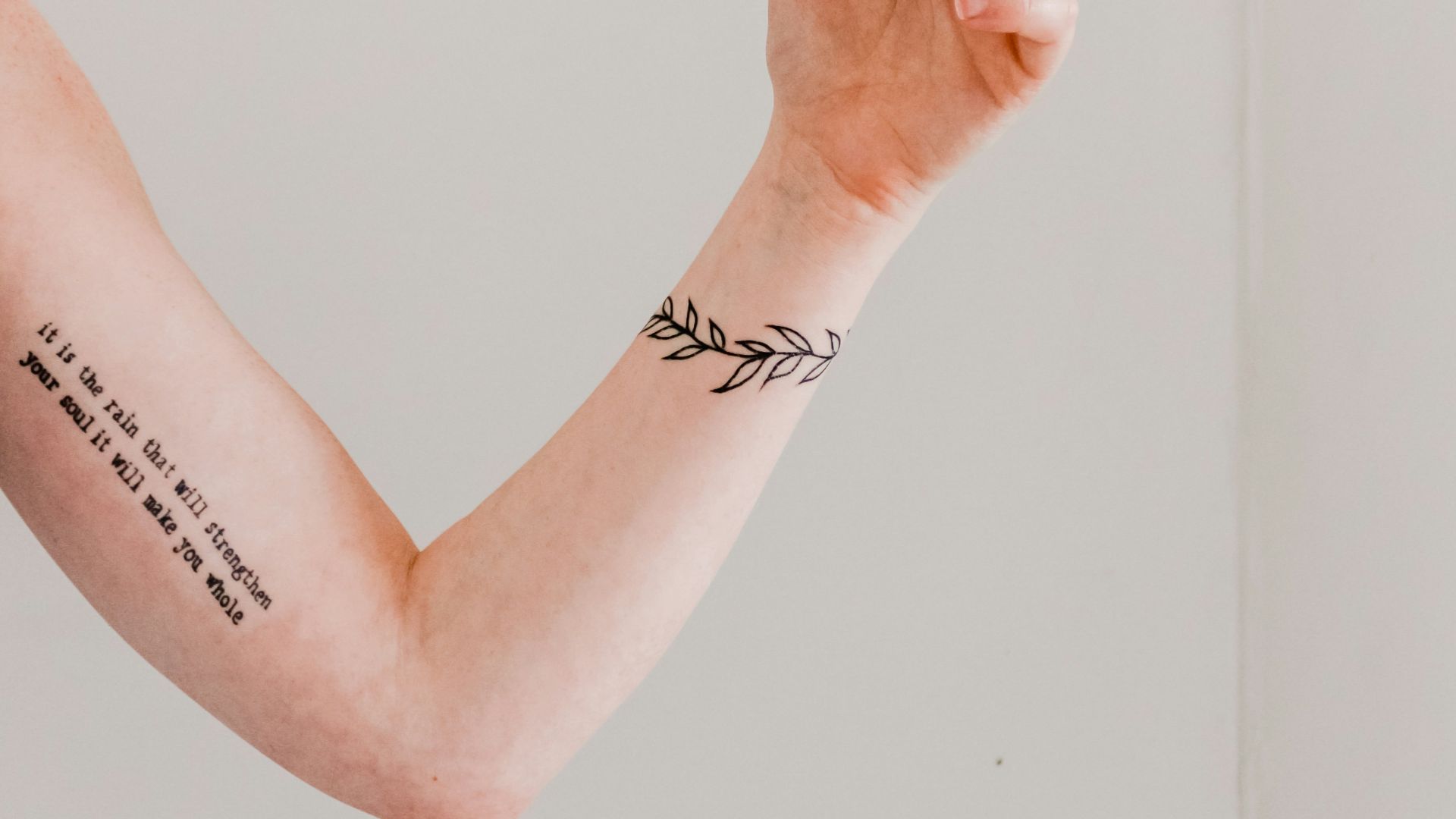 person showing arm and wrist tattoo