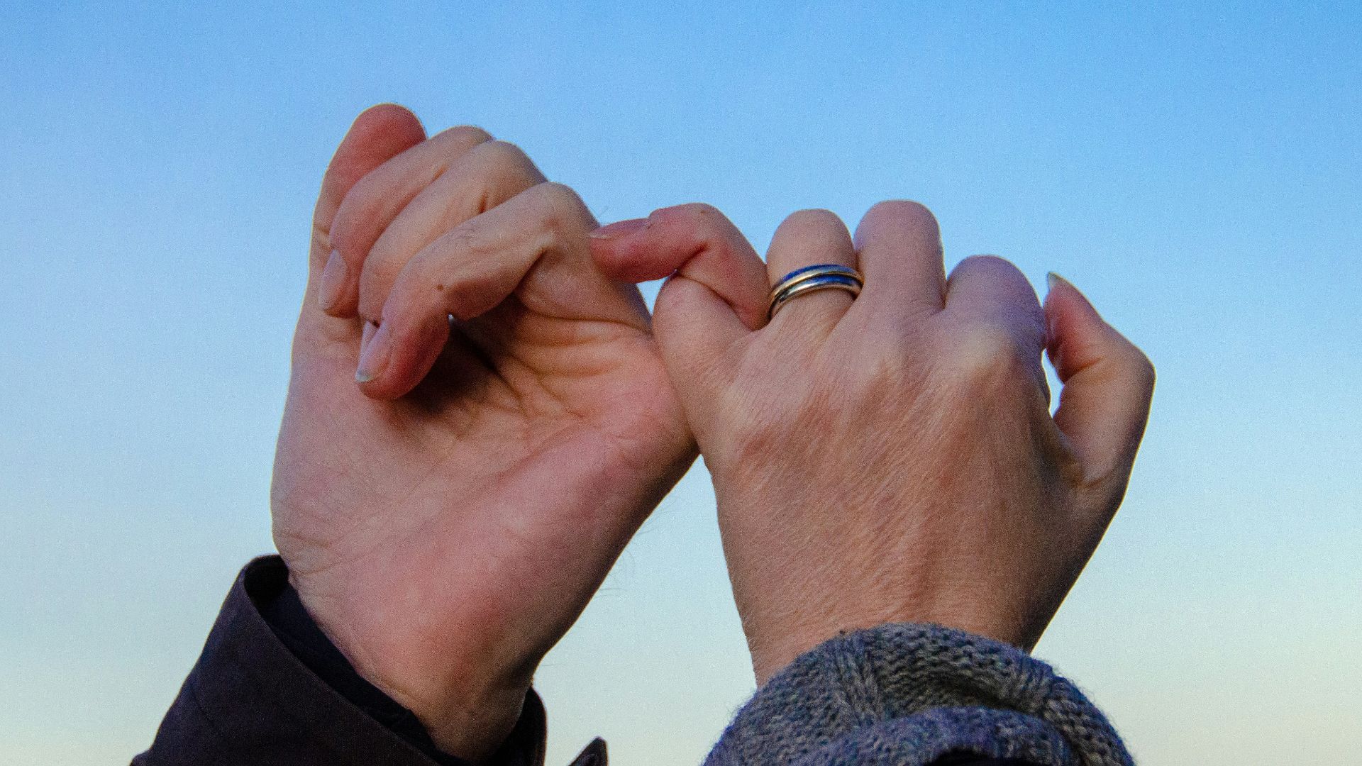 person in gray sweater with silver ring