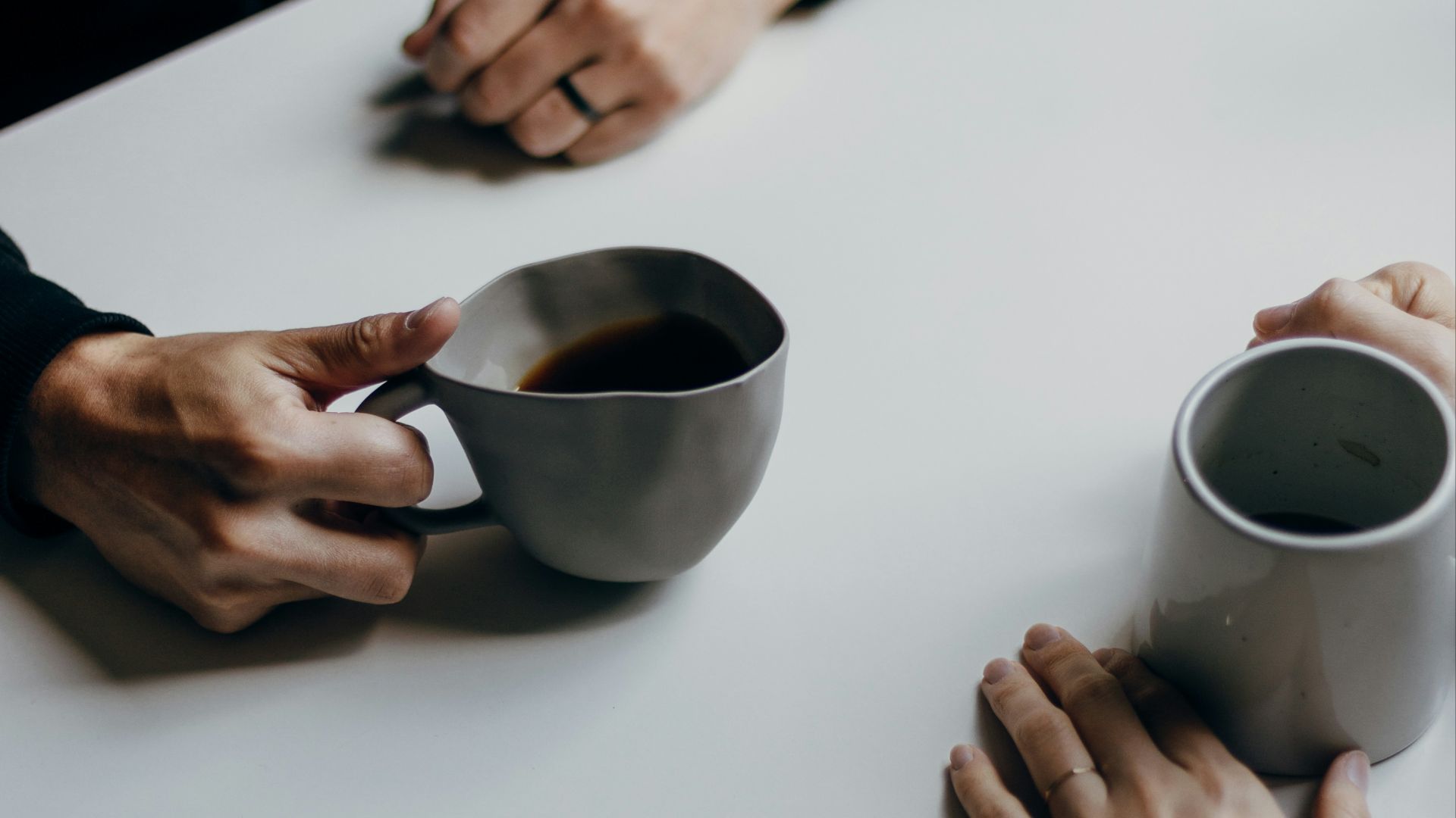 a couple of people sitting at a table with cups of coffee