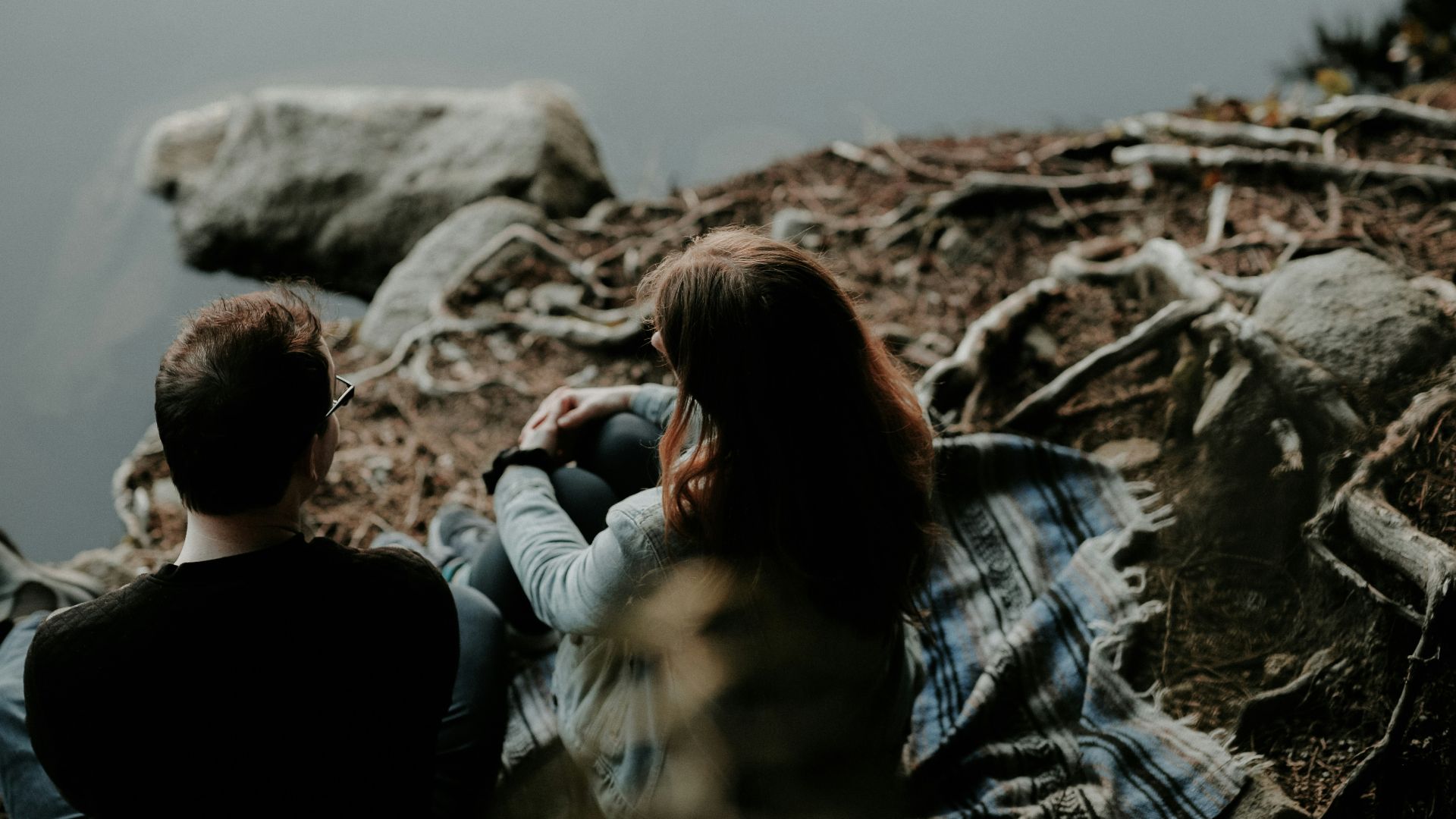 couple sitting near the body of water