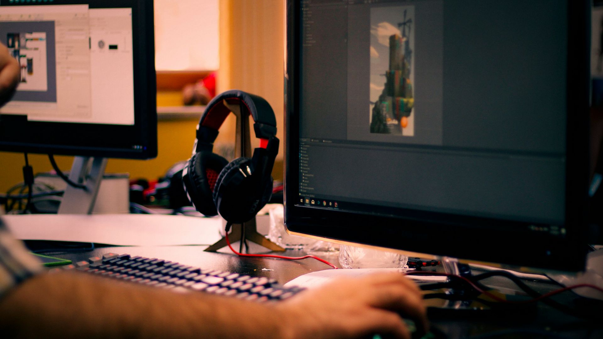 person holding mouse in front of monitor