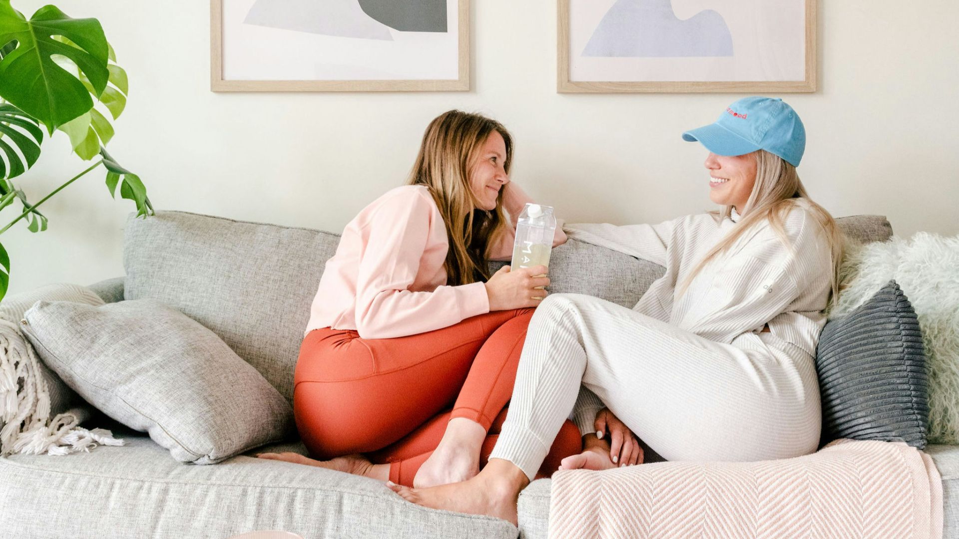 two women sitting on a couch in a living room