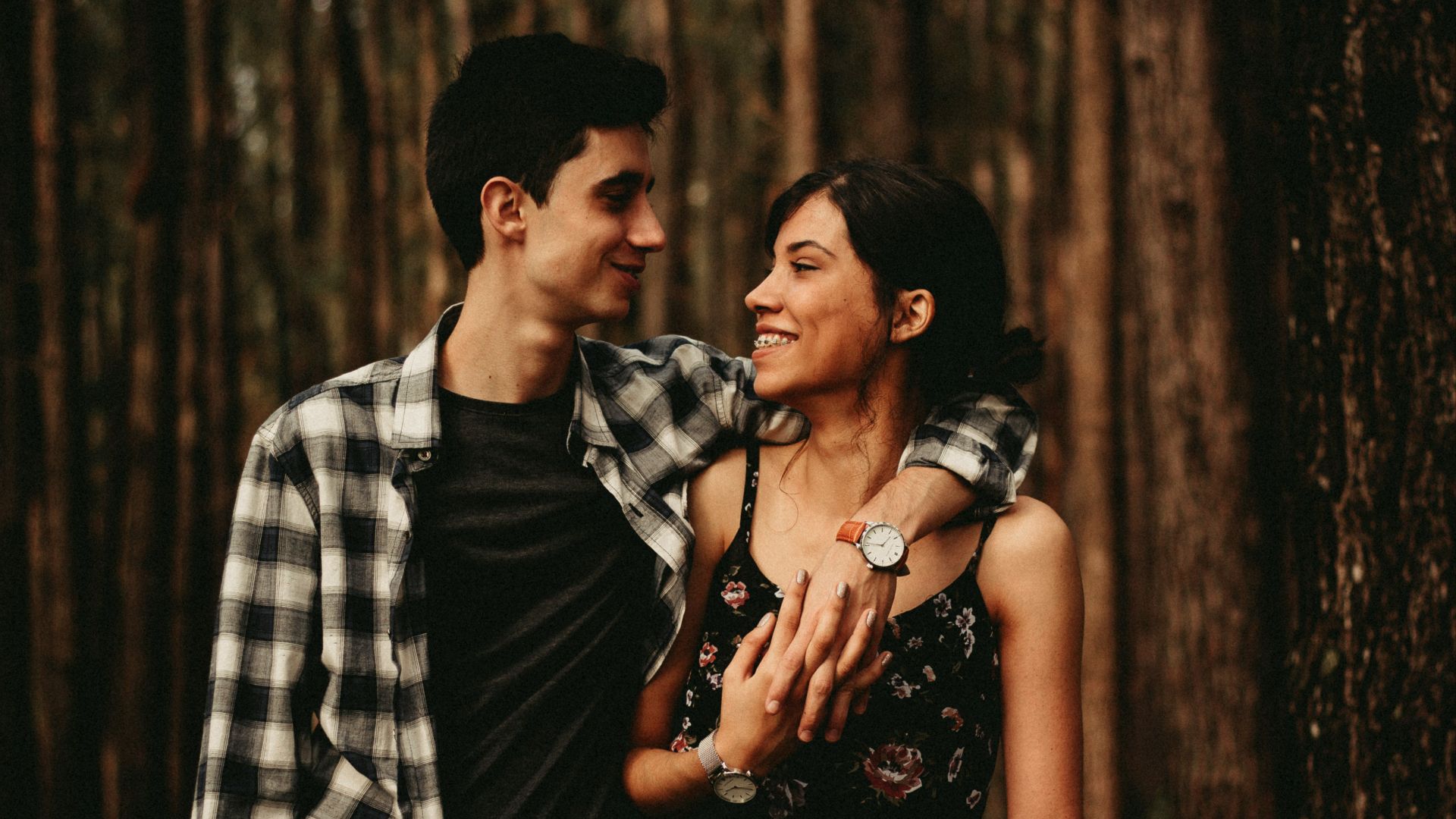 man wrapping arm on woman facing each other
