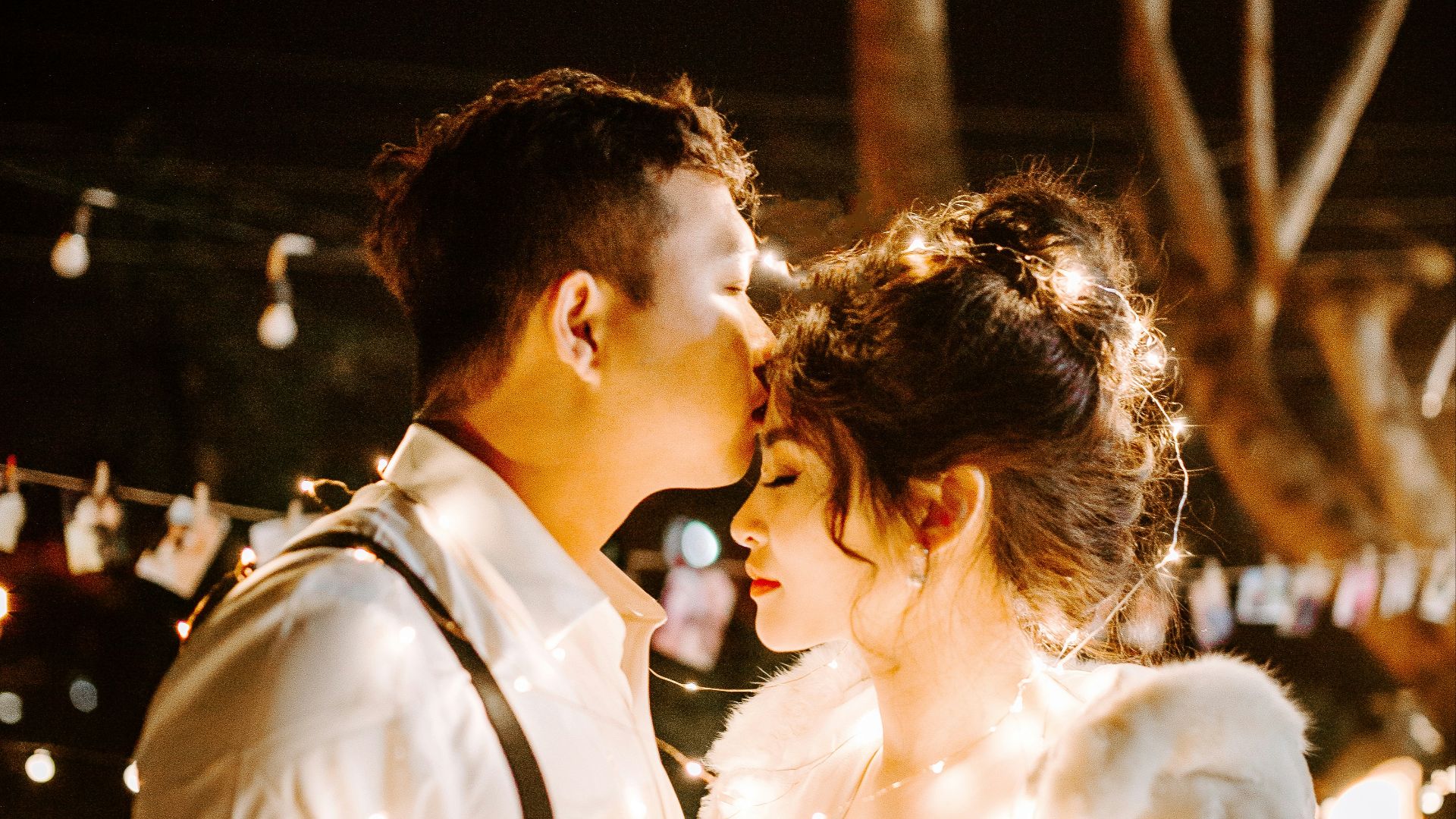 man kissing woman's forehead