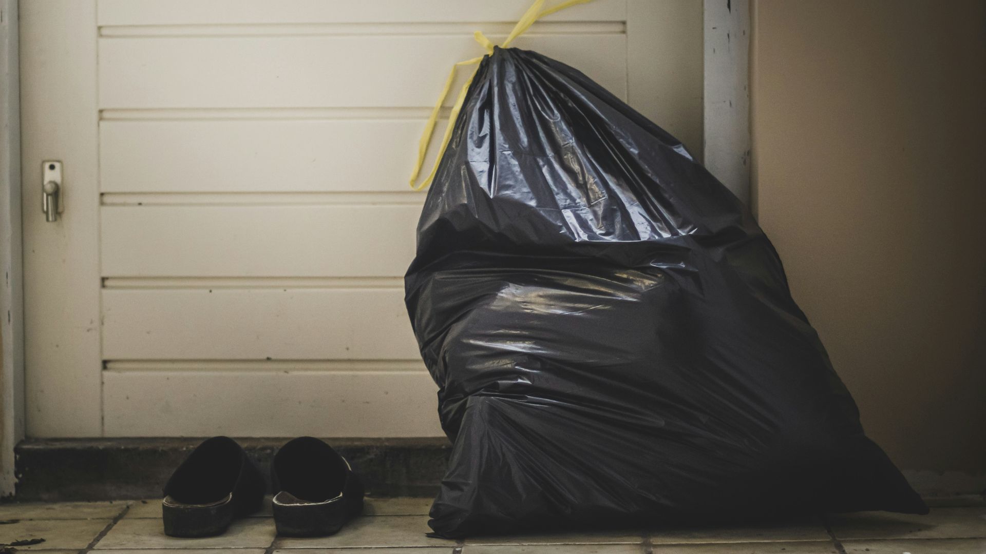 black plastic bag beside white wall