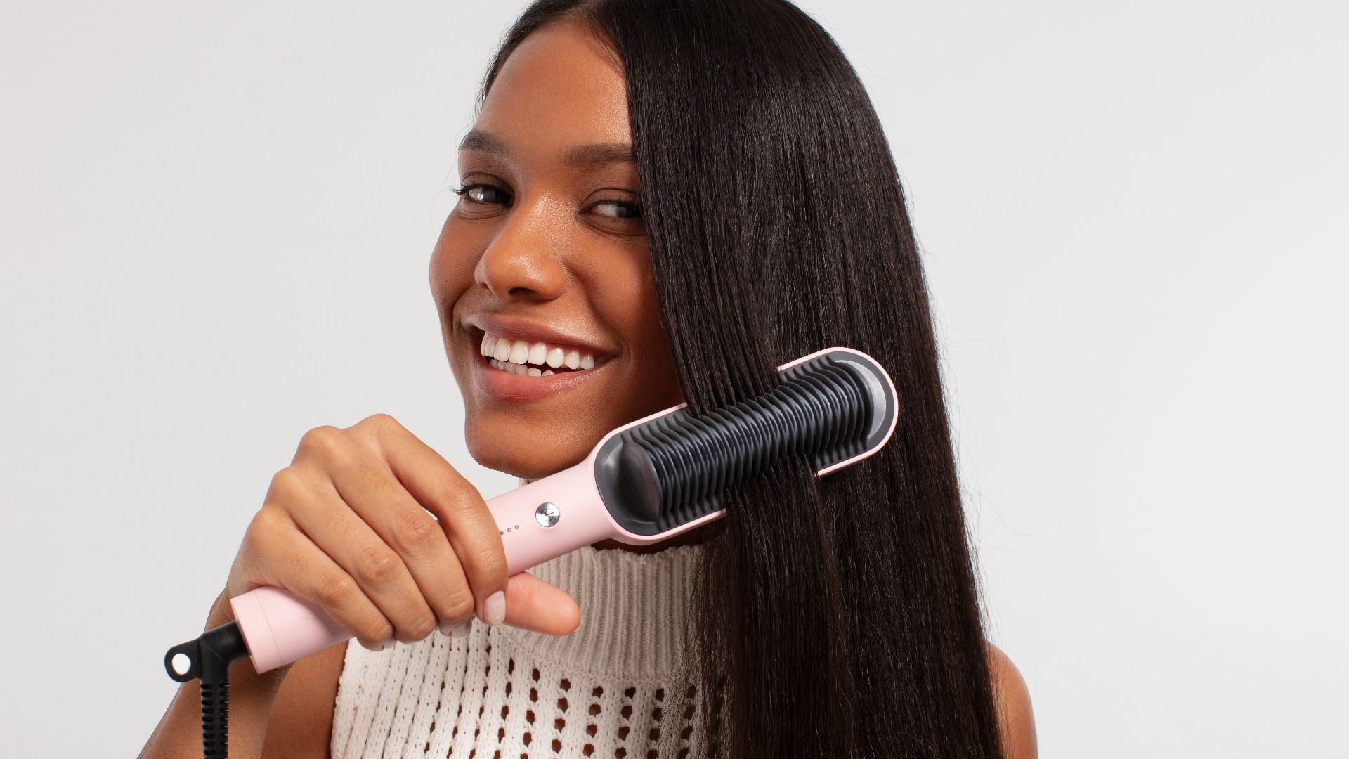 a woman using a hair dryer on her long hair