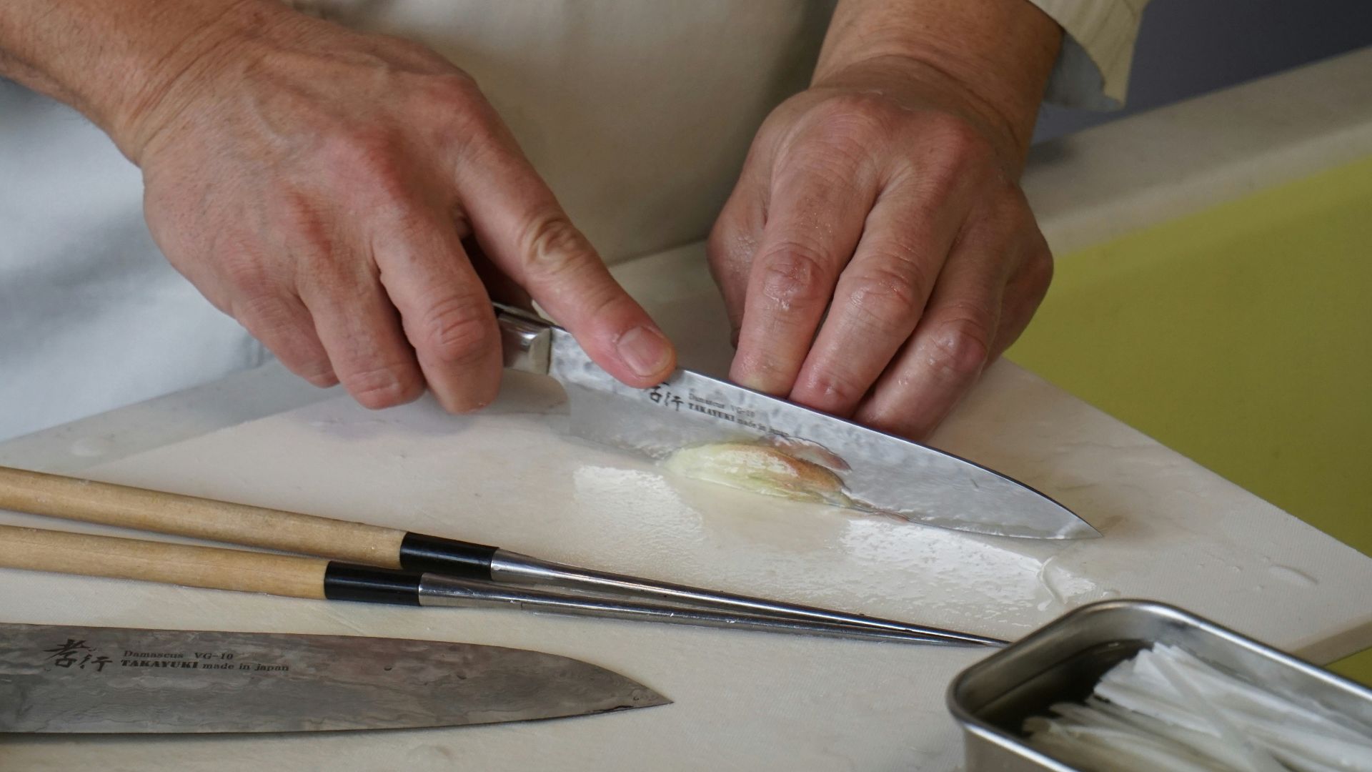 person in white button up shirt holding silver knife