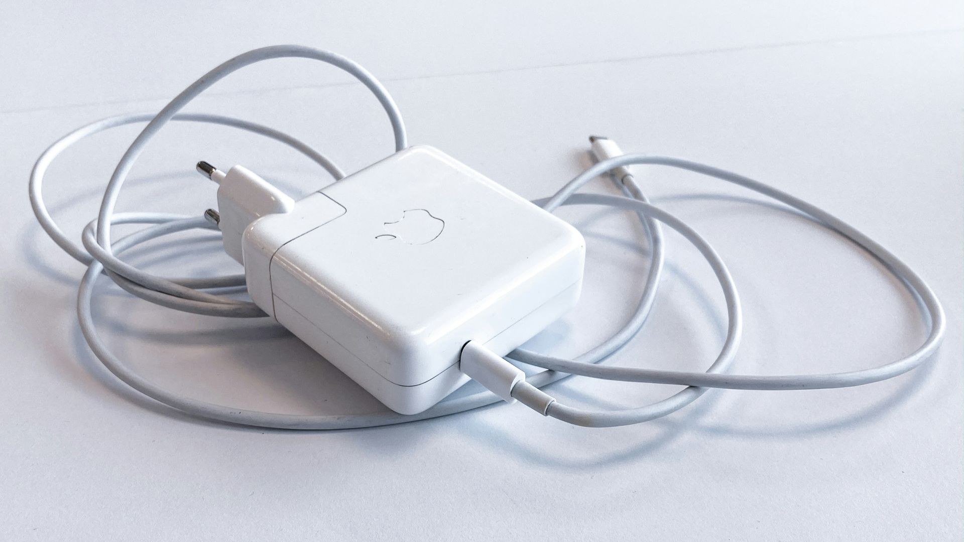 white apple charging adapter on white table