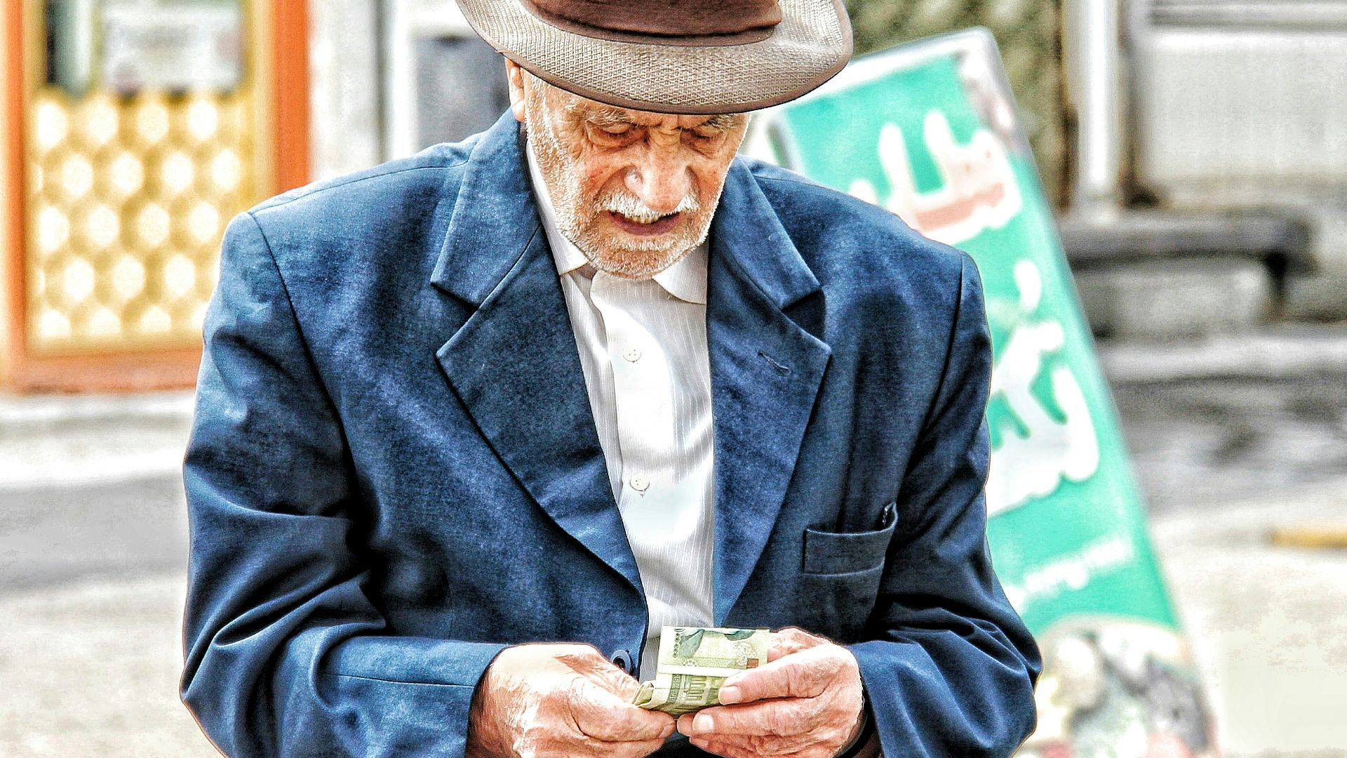 a man in a hat holding a glass of beer