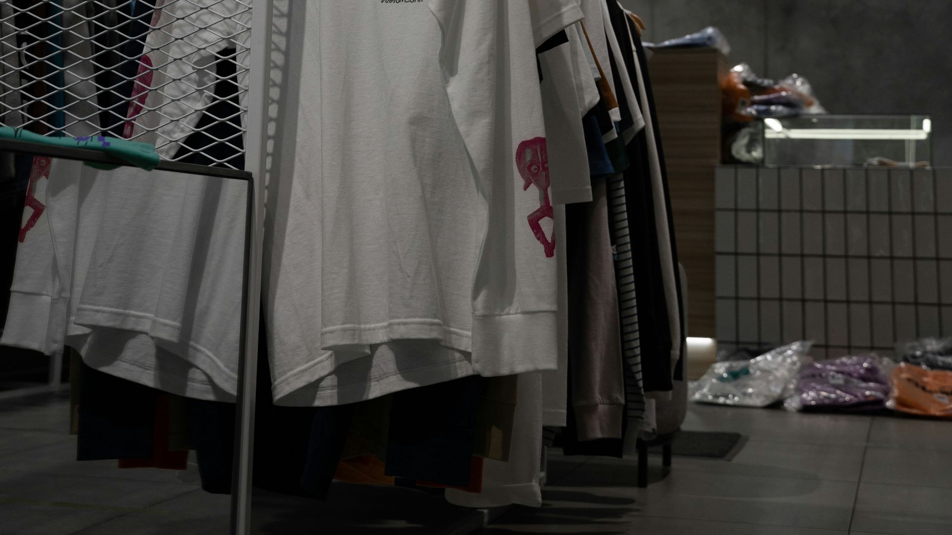 white polo shirt hanging on gray metal rack