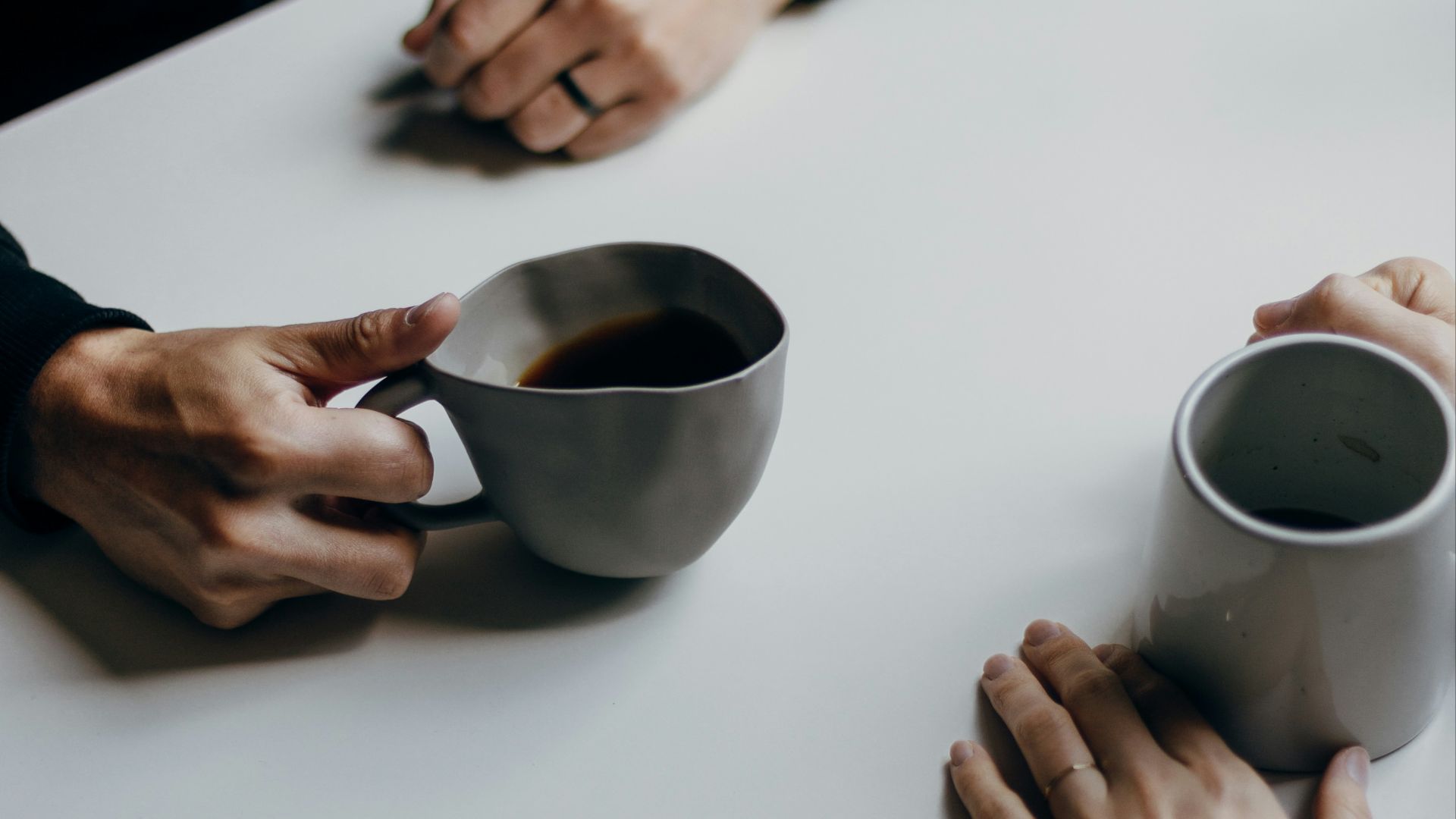 a couple of people sitting at a table with cups of coffee