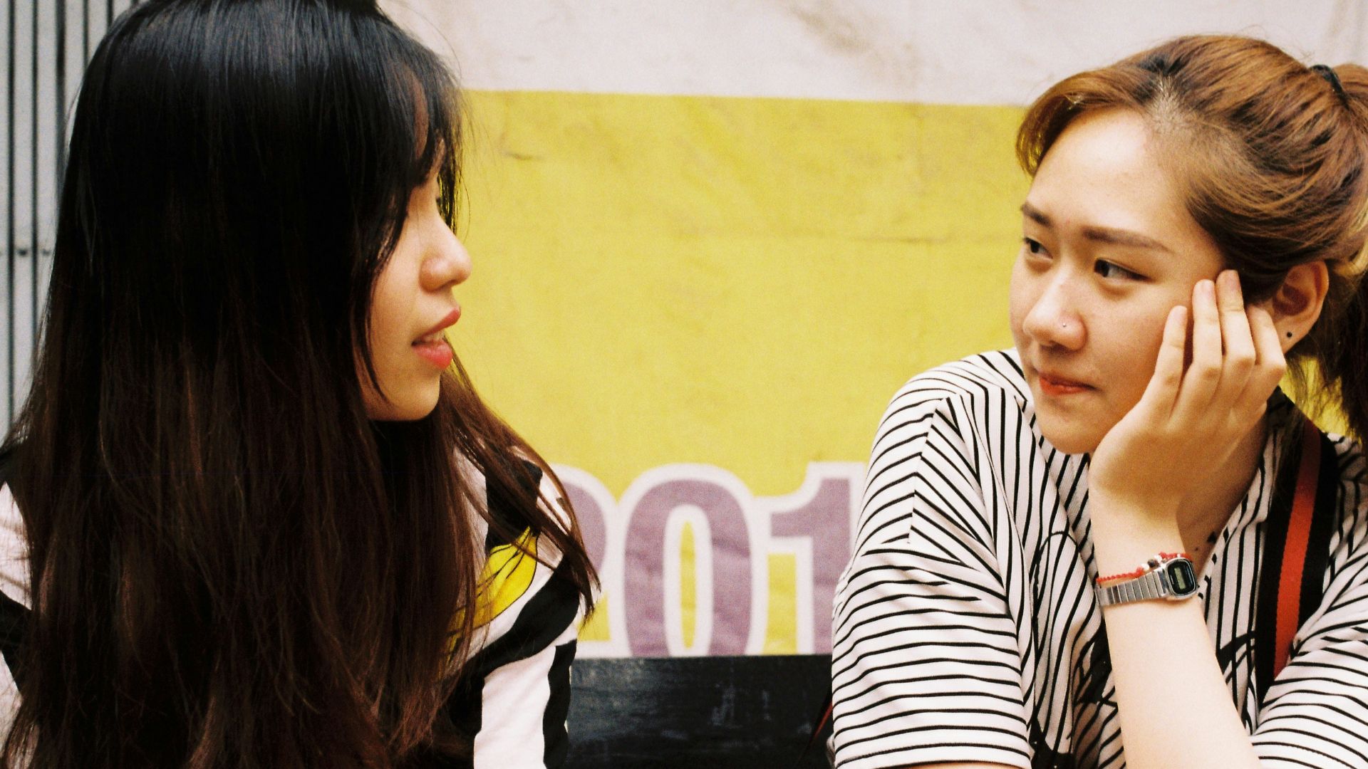 woman in white-and-black striped tops looking each other