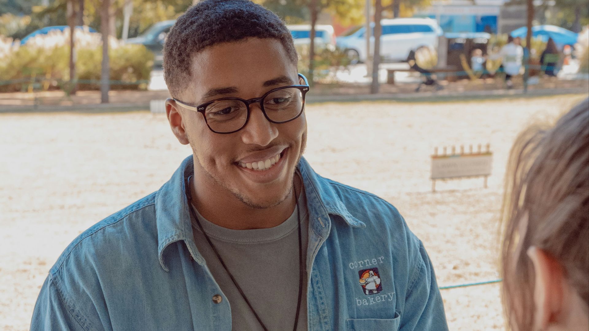 man wearing blue denim button-up shirt facing on human