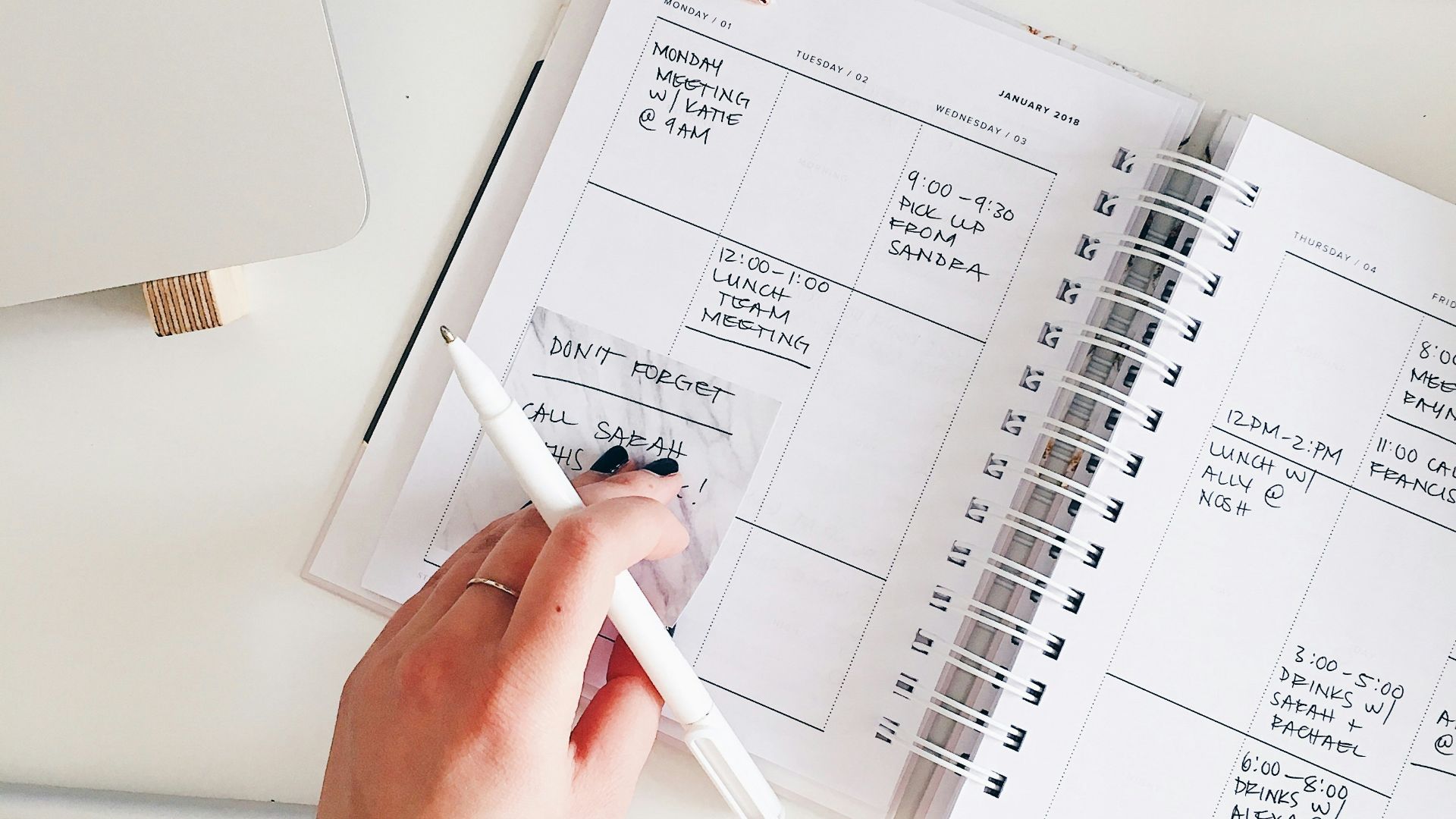 person holding notepad and pen flat lay photography