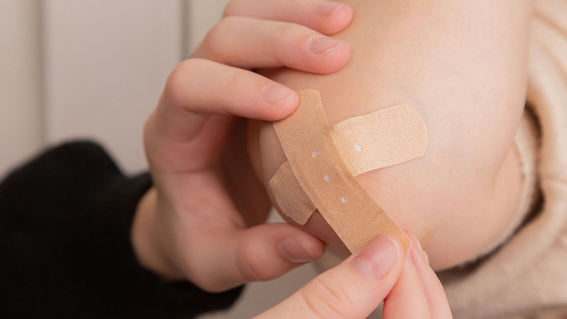 person holding band aid on left hand