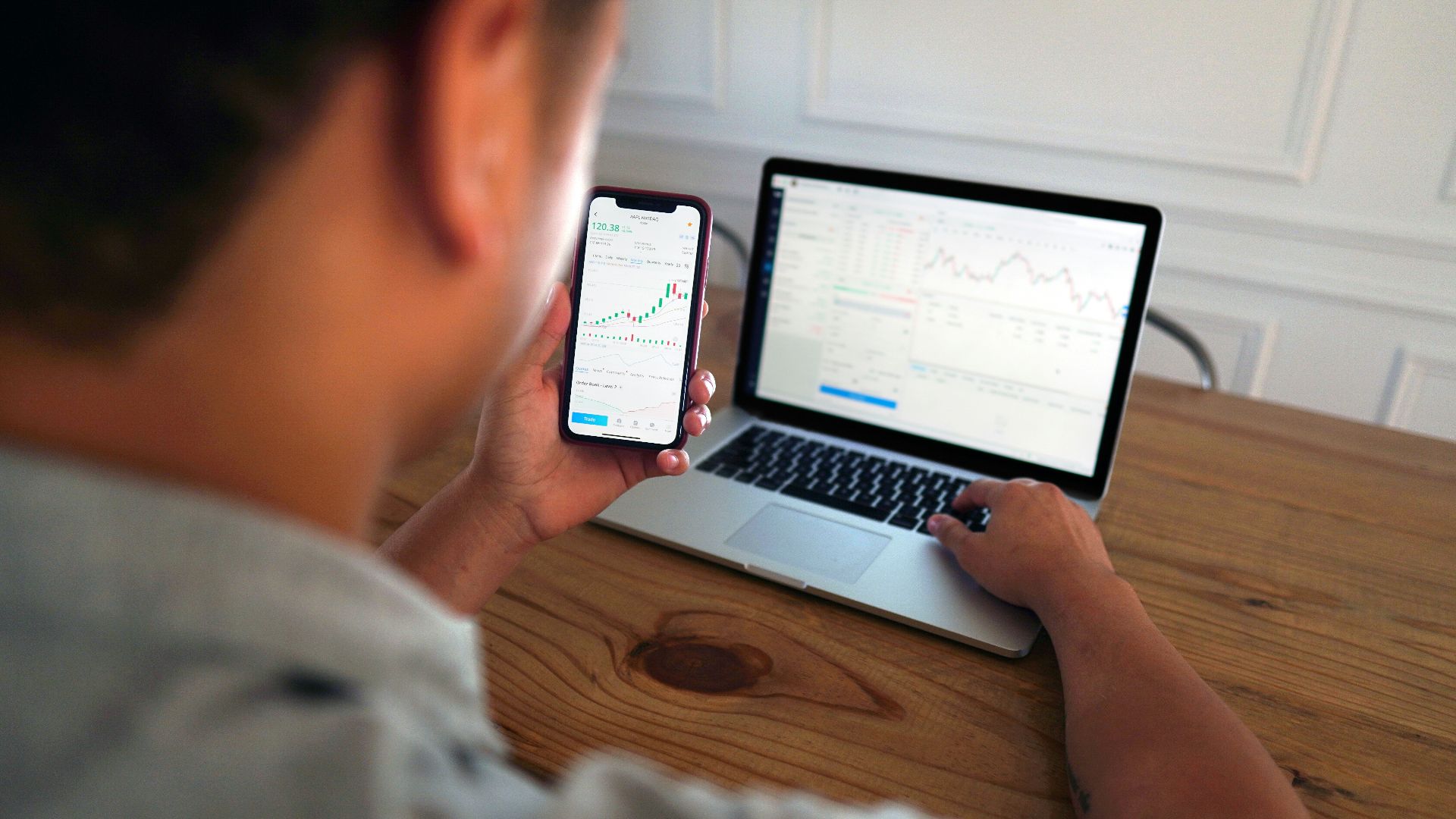 man in gray hoodie holding black smartphone