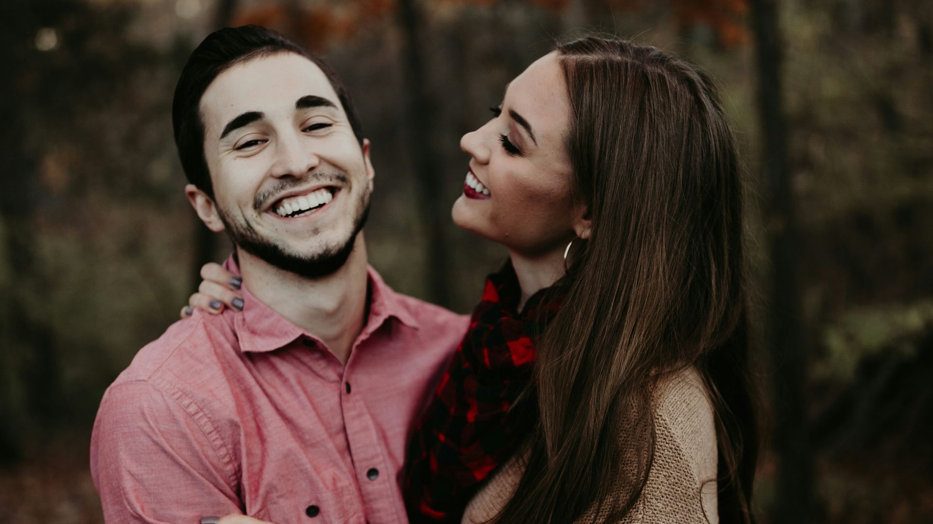 woman hugging man selective focus photography