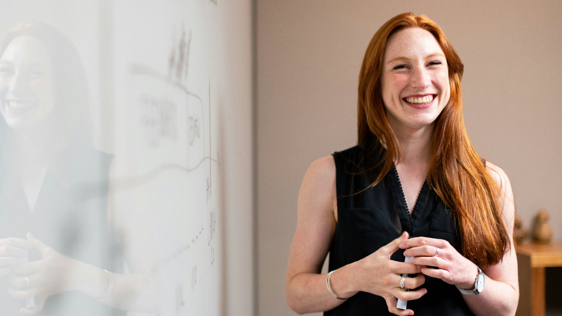 woman in blue tank top standing beside white wall