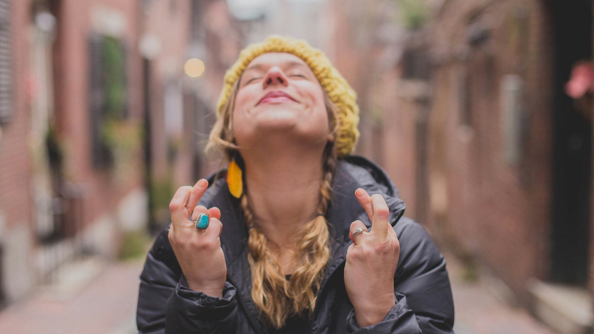 woman in black jacket wearing yellow knit cap
