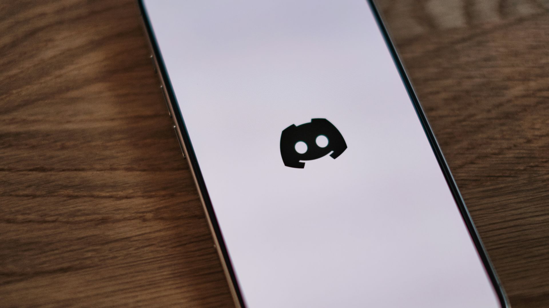 A cell phone sitting on top of a wooden table