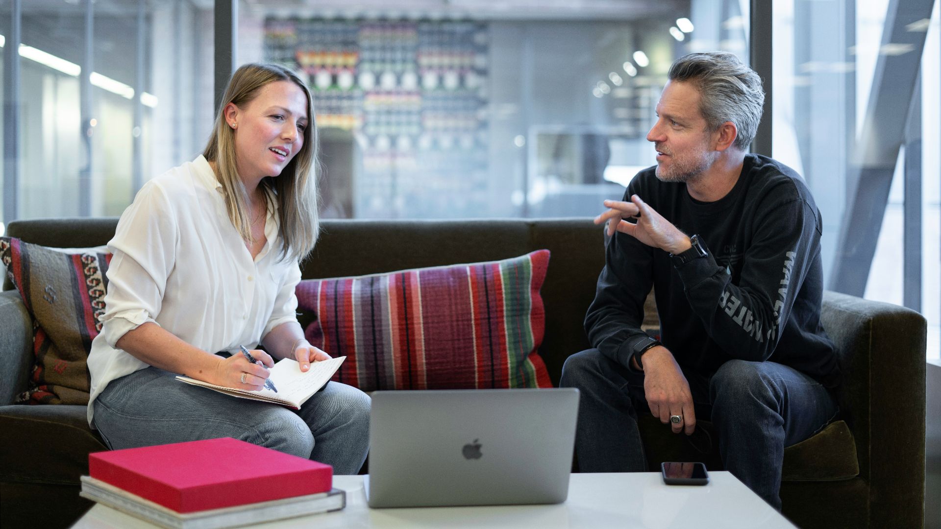 woman in white long sleeve shirt sitting on red couch