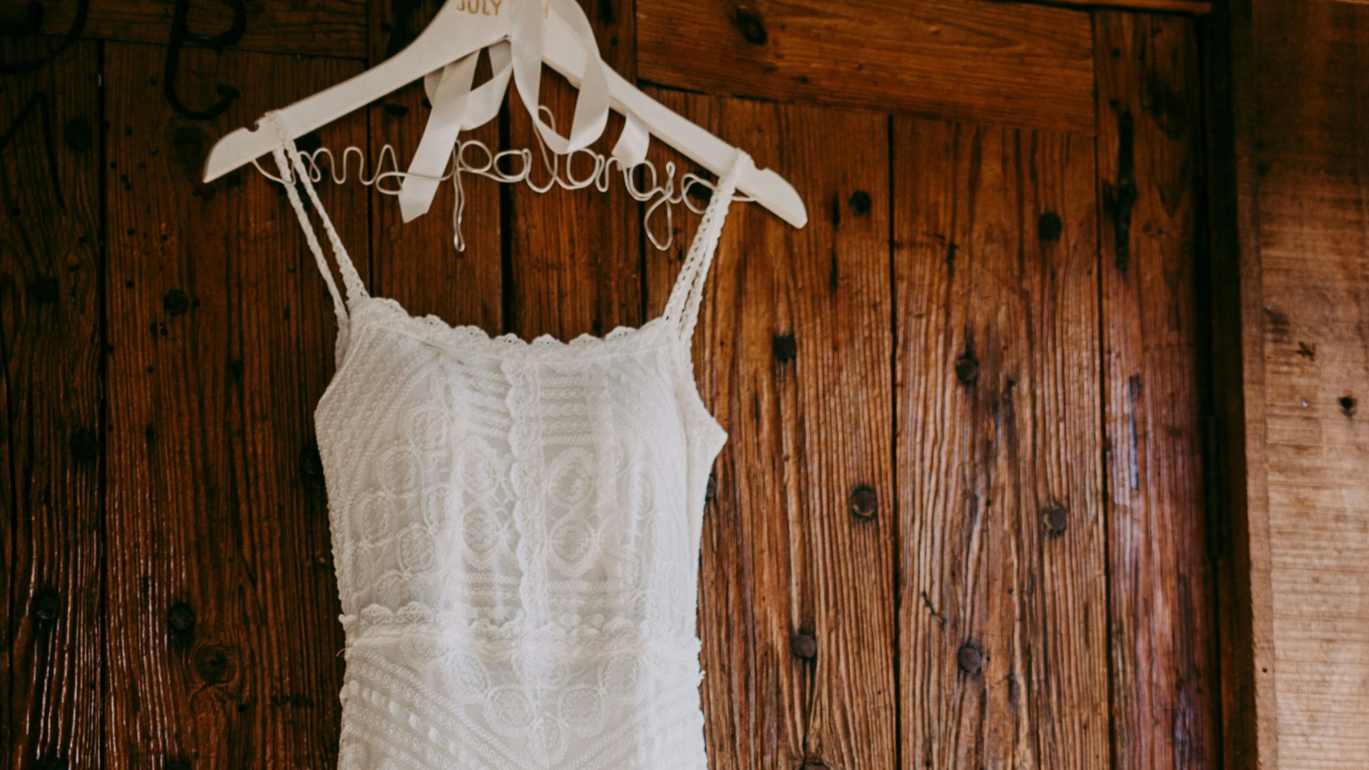 white sleeveless dress near brown wooden door