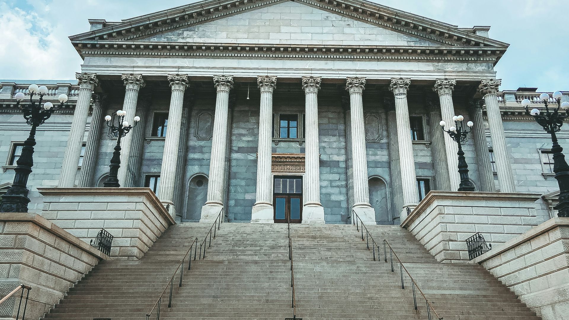 a large building with columns and a flag on top