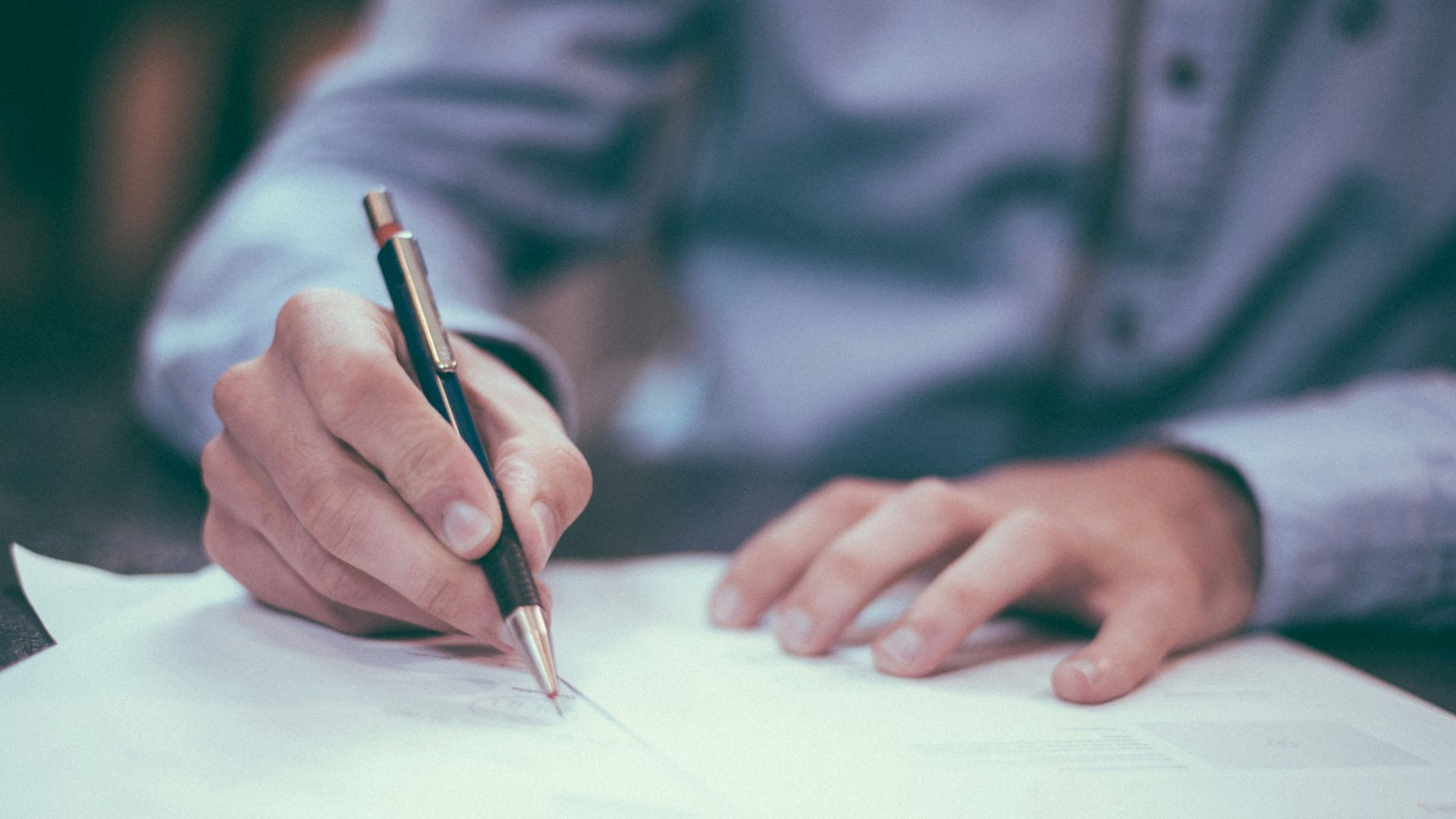 man writing on paper